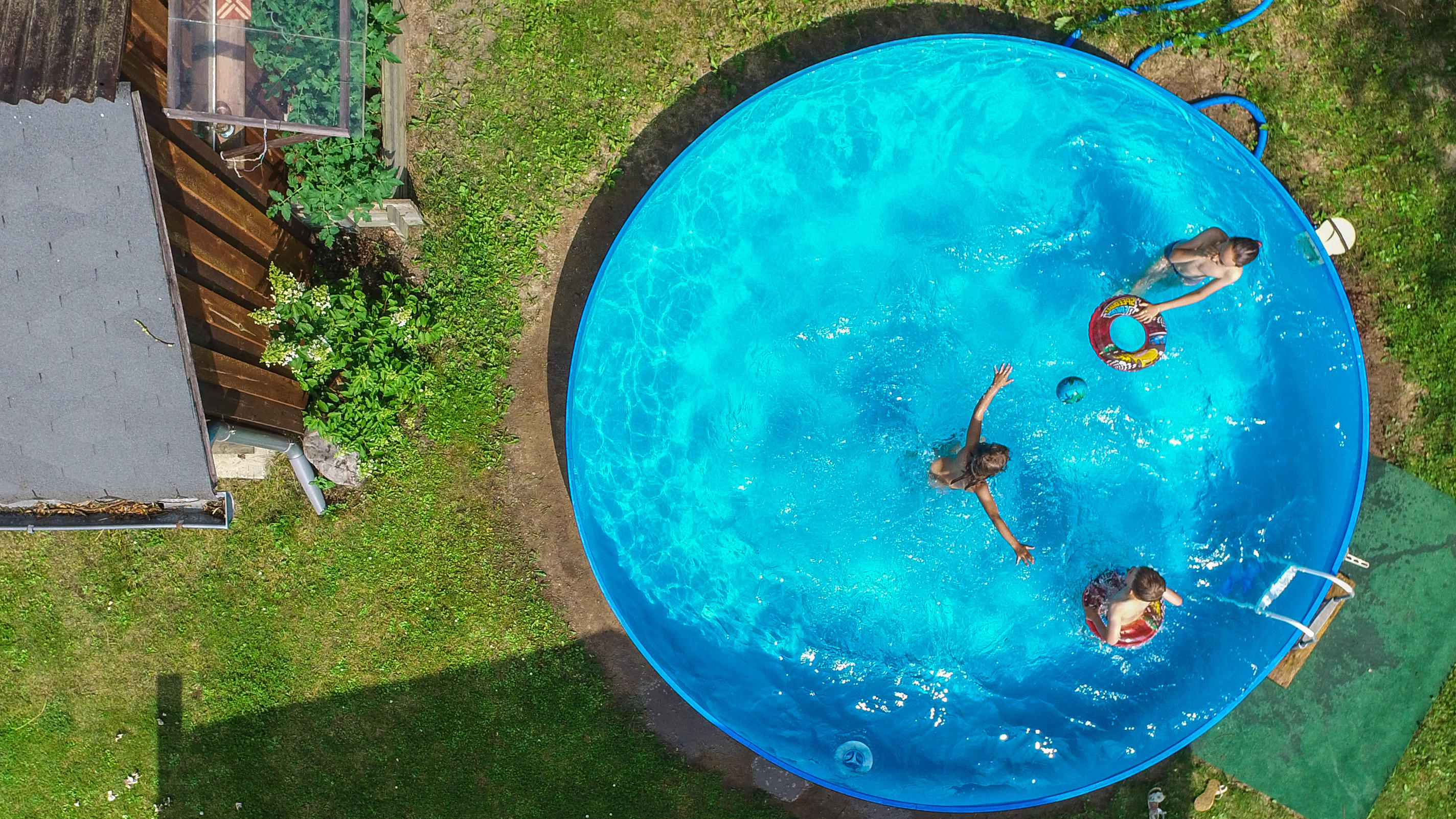 Pfingsten im Garten: So wird der Kurzurlaub zu Hause ein Fest! ARCHIV - 09.07.2017, Brandenburg, Petersdorf: Kinder planschen in einem Garten im Pool. (Luftaufnahme mit einer Drohne, zu dpa «Unsichtbare Gefahr im Gartenpool» vom 10.06.2018) Foto: Patrick Pleul/dpa-Zentralbild/dpa +++ dpa-Bildfunk +++