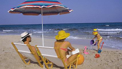 Reisewetter bis 19.08.2018 für Spanien mit Mallorca, Italien, Frankreich, die Kanaren & Co. Ein junges Paar sitzt in Liegestühlen unter dem Sonnenschirm am Meeresstrand, ihre kleine Tochter spielt im Sand.