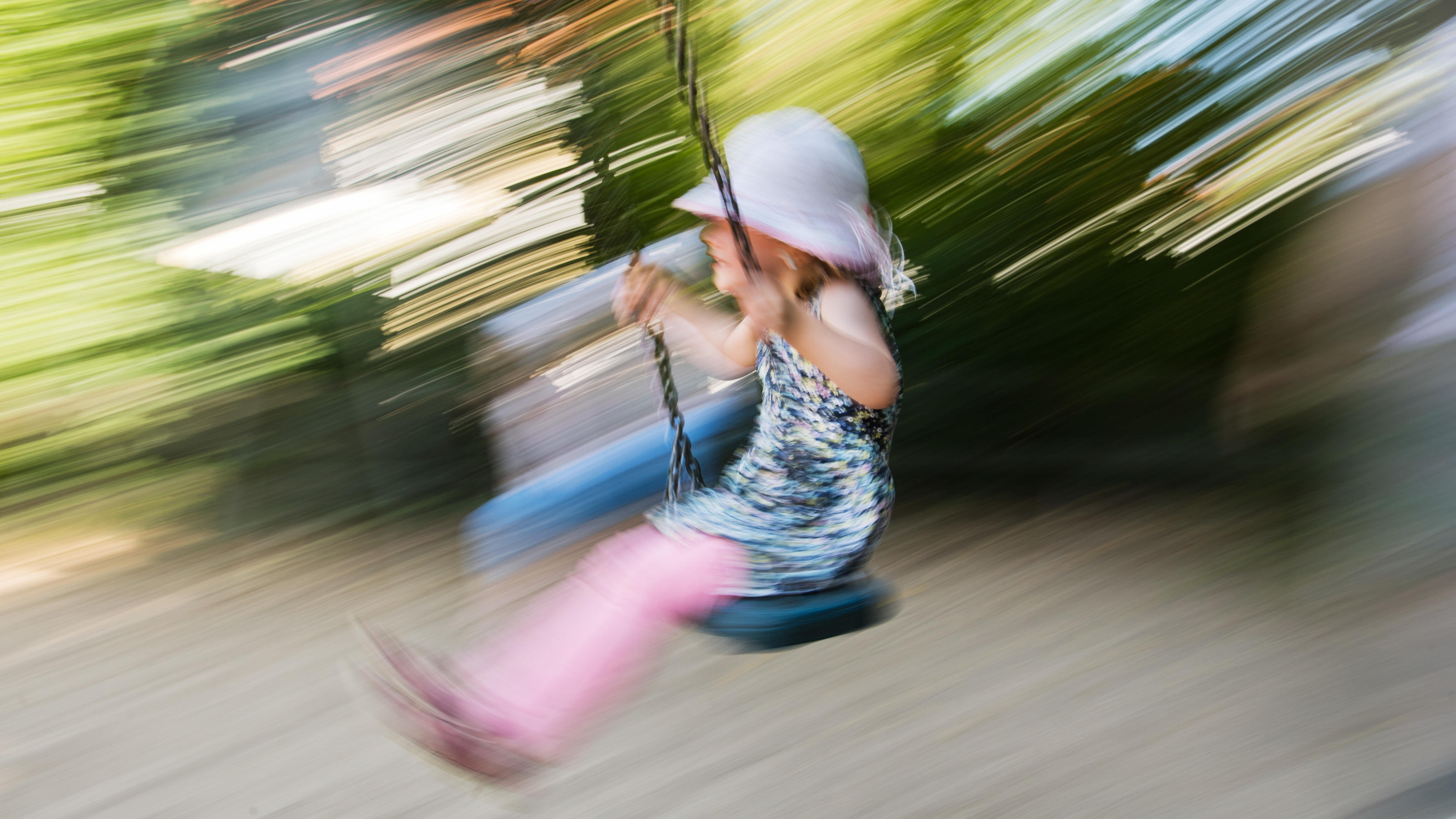 Autos verdrängen unsere Kinder: Platz zum Spielen in Großstädten immer knapper Ein kleines Mädchen schaukelt auf einem Spielplatz.