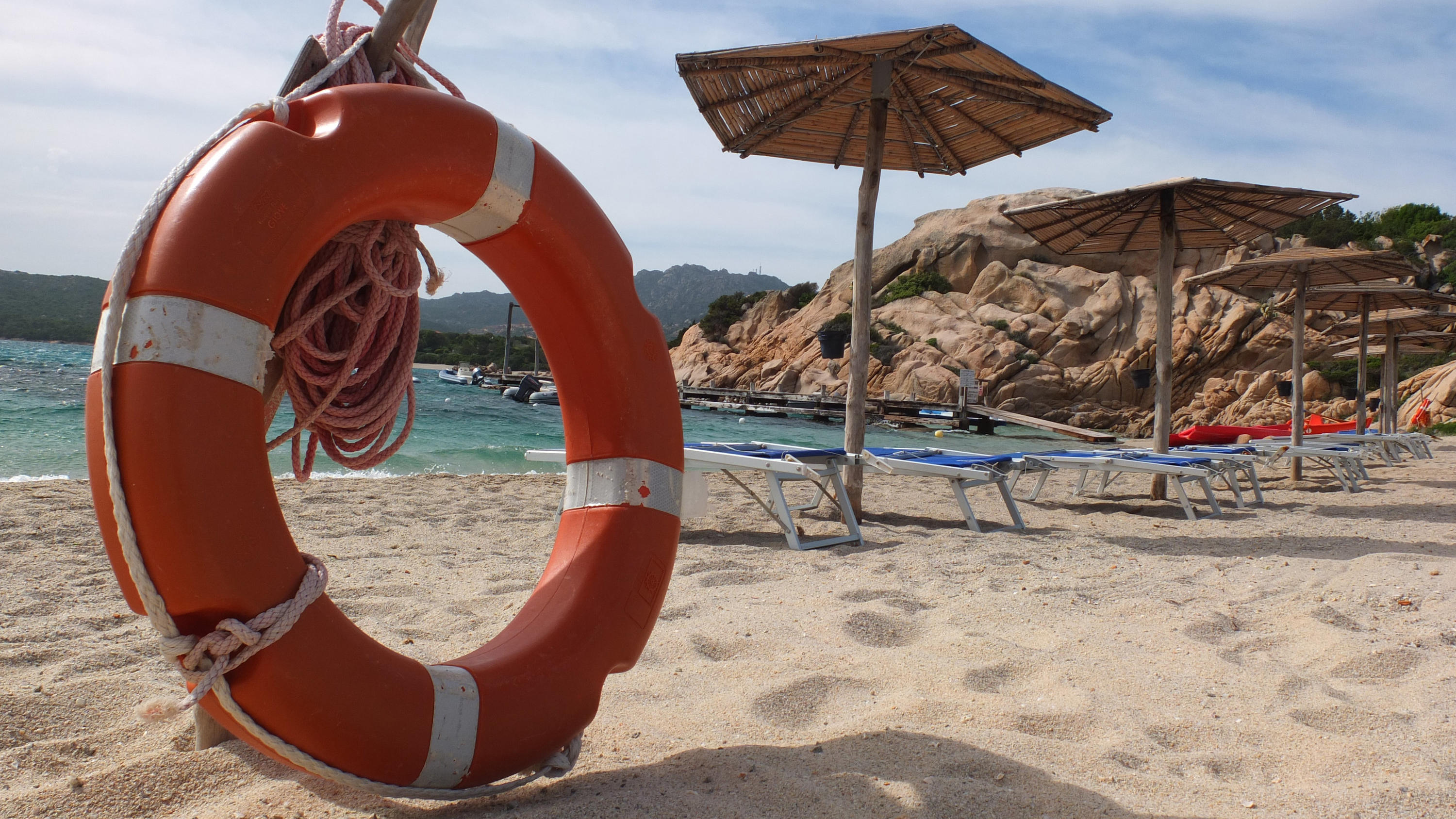 Sicher reisen trotz Corona: In diesen Reiseländern liegen wir noch im grünen Bereich ARCHIV - 13.05.2012, Italien, Sardinien: Ein Rettungsring stehen neben Sonnenliegen und Schirmen am Sandstrand von Capriccioli. (zu dpa Sand mitnehmen verboten - Warnung an deutsche Sardinien-Touristen vom 03.08.2018) Foto: Marcus Brandt/dpa +++ dpa-