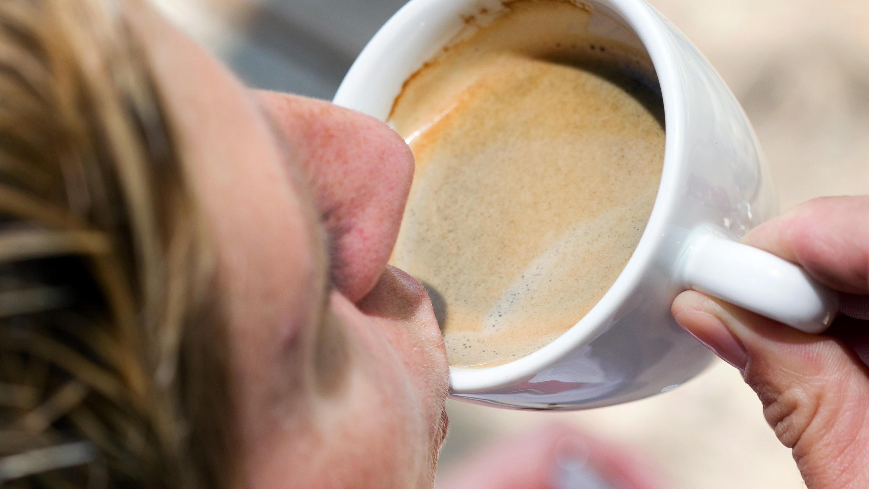 Kaffee mit Zitrone soll die Pfunde purzeln lassen Eine Frau trinkt eine Tasse Kaffee-Crema. dpa