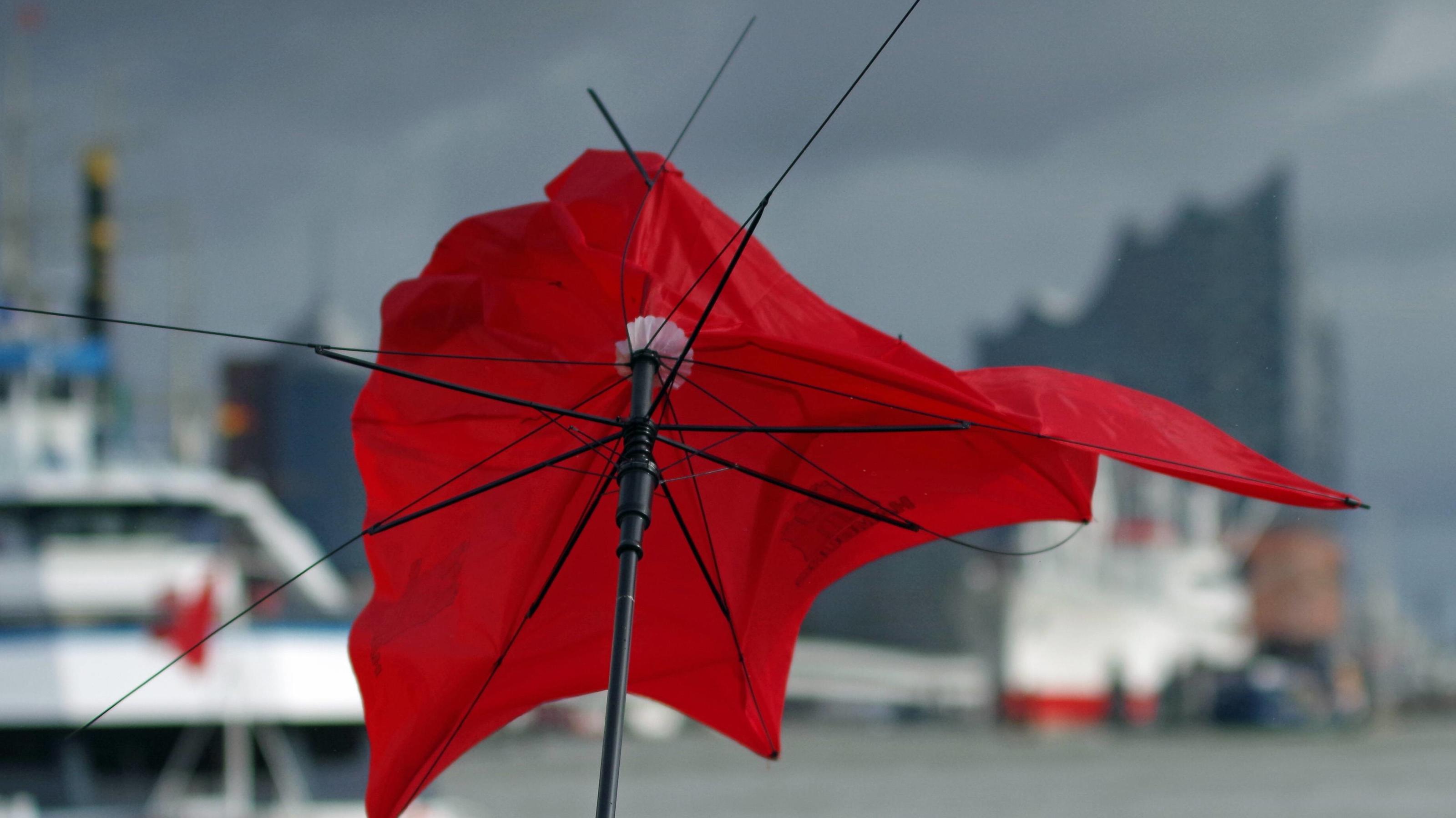 Wettercomputer berechnen den ersten Sturm im Herbst 2021 Sturm Xavier über Hamburg: An den Landungsbrücken geht ein Regenschirm im teils orkanartigen Wind zu Bruch. *** Storm Xavier above Hamburg to the Landungsbrücken is a Umbrella in sometimes orkanartigen Wind