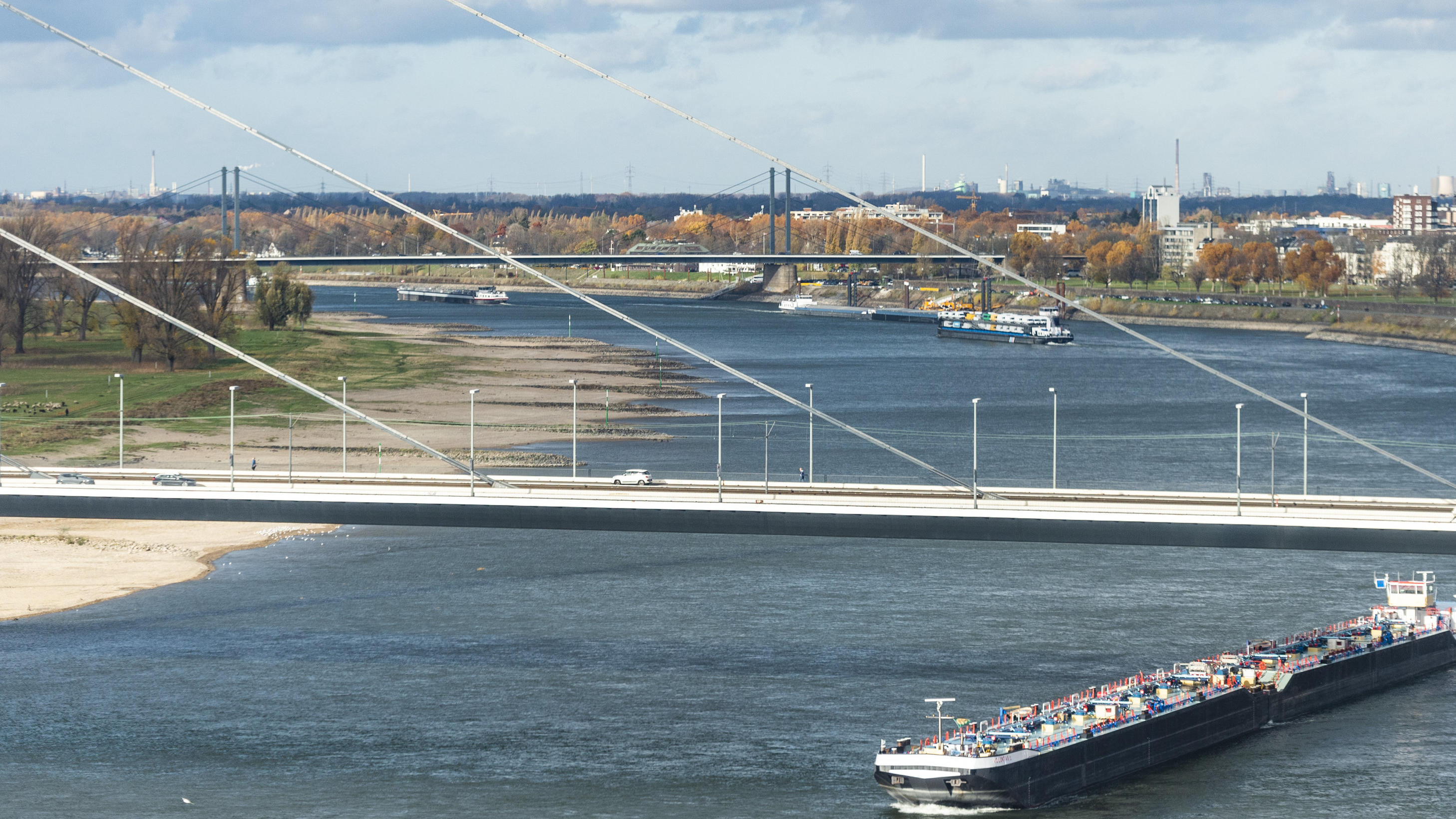 Die Pegelstände bleiben trotz Regen tief unten 13.11.2018, Nordrhein-Westfalen, Düsseldorf: Ein Transportschiff fährt auf dem Rhein unter der Oberkasseler Brücke entlang. Foto: Christophe Gateau/dpa +++ dpa-Bildfunk +++