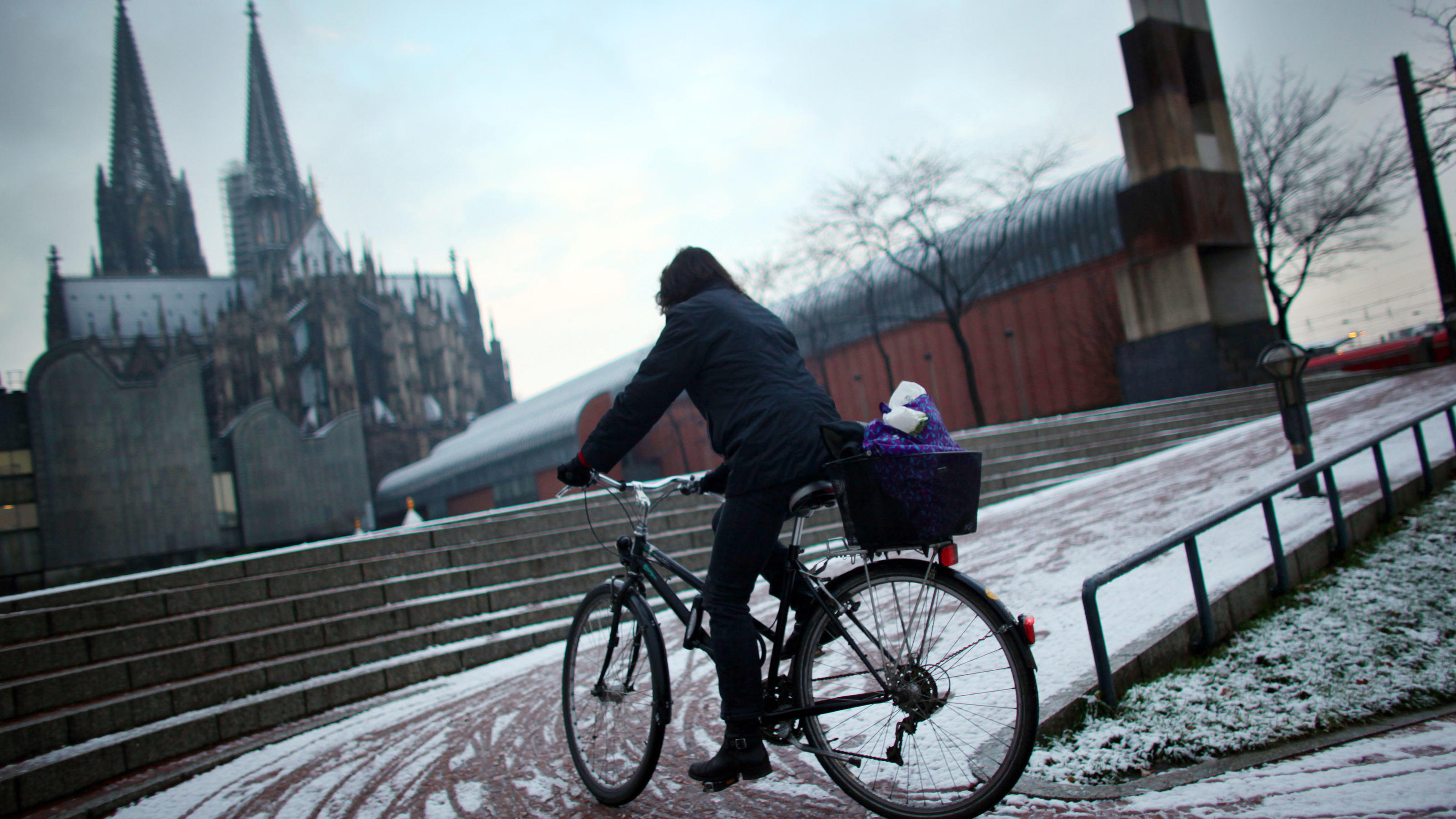 Winter-Prognose 2019: Kann man anhand von Sonnenflecken vorhersagen, wie kalt der Winter wird? Auf dem Fahrrad fährt am Freitagmorgen (26.11.2010) in Köln eine Frau durch die Stadt. Leichte Niederschläge am frühen Morgen haben in Köln für den ersten Schnee im Flachland gesorgt. Foto: Oliver Berg dpa/lnw | Verwendung weltweit
