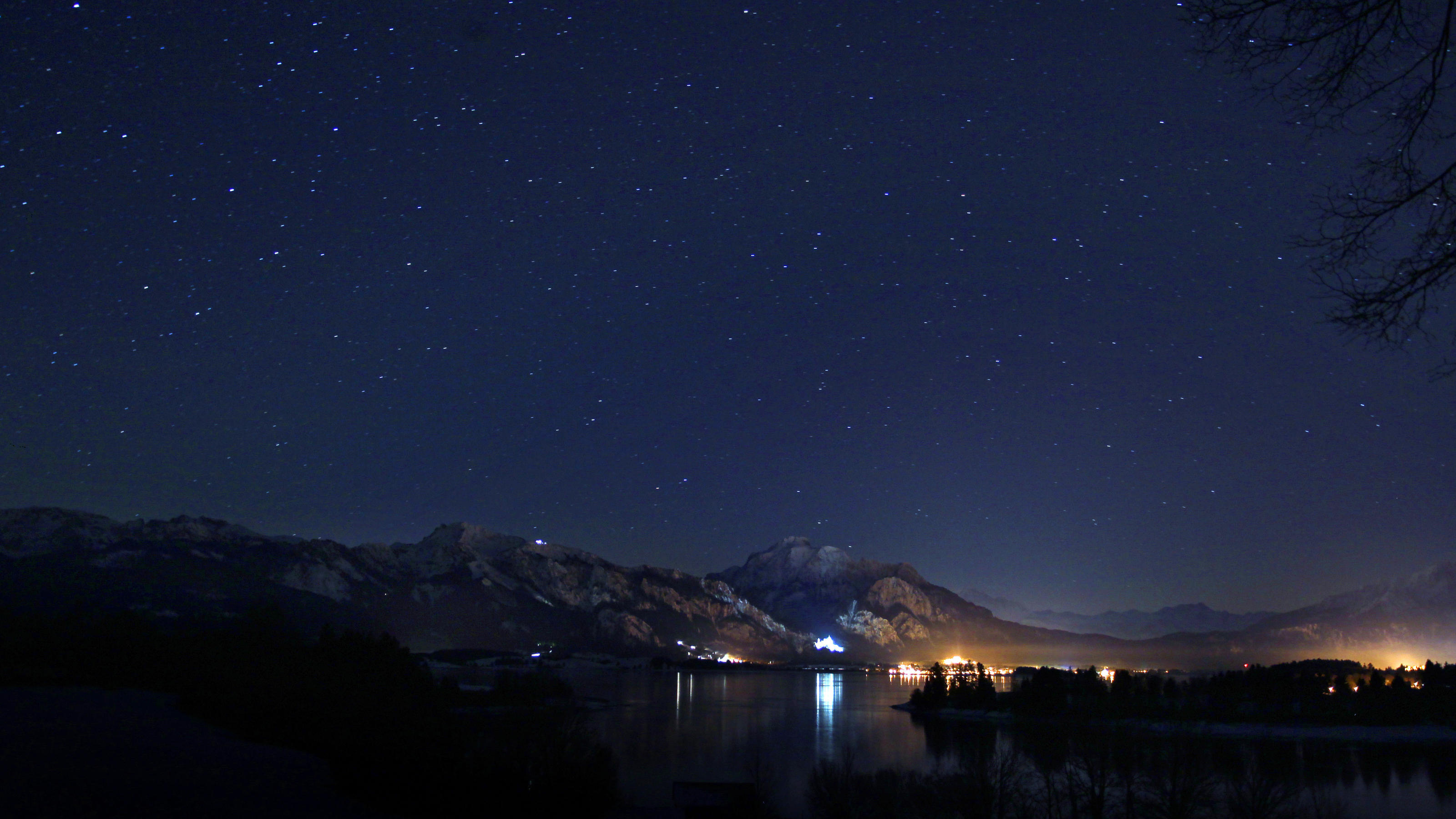 Wetter am Wochenende mit eiskalten Temperaturen Unter einem wolkenlosen Sternenhimmel spiegeln sich am Montag (16.01.2012) die Lichter des Schlosses Neuschwanstein und der Stadt Füssen (Schwaben) im Forggensee. Sonne am Tag und kalte klare Nächte bestimmen das Wetter im südwestlichen Bayern. Foto: