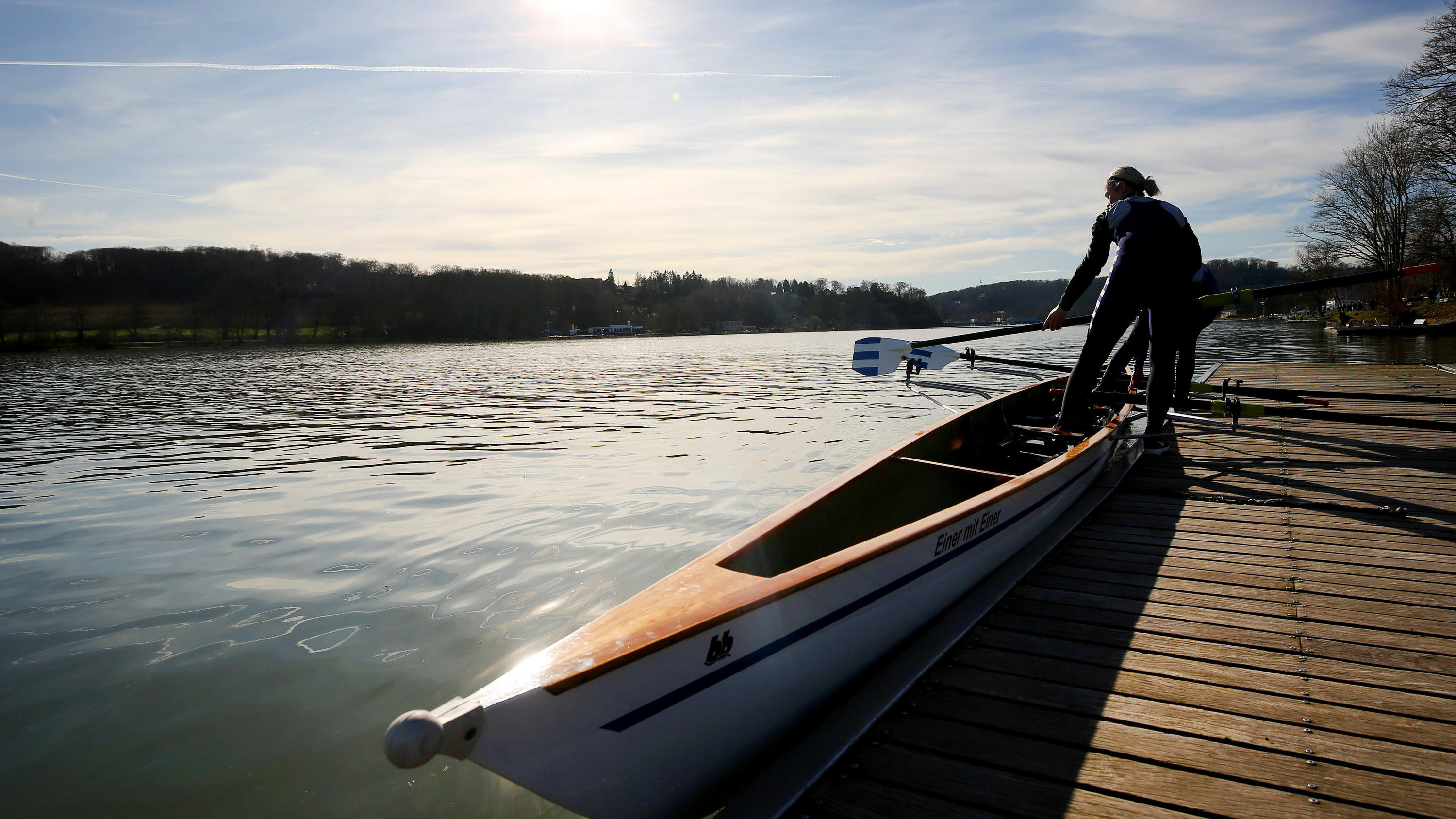 Der Februar-Frühling wird verlängert: Auch am Montag noch super 14.02.2019, Nordrhein-Westfalen, Essen: Ihr Ruderboot lassen zwei Frauen vom Ruderclub am Baldeneysee (RaB) zu Wasser. Bei strahlendem Sonnenschein ist es rund 15 Grad warm und soll am Wochenende auch so frühlingshaft bleiben. Foto: Roland Weihrauch/