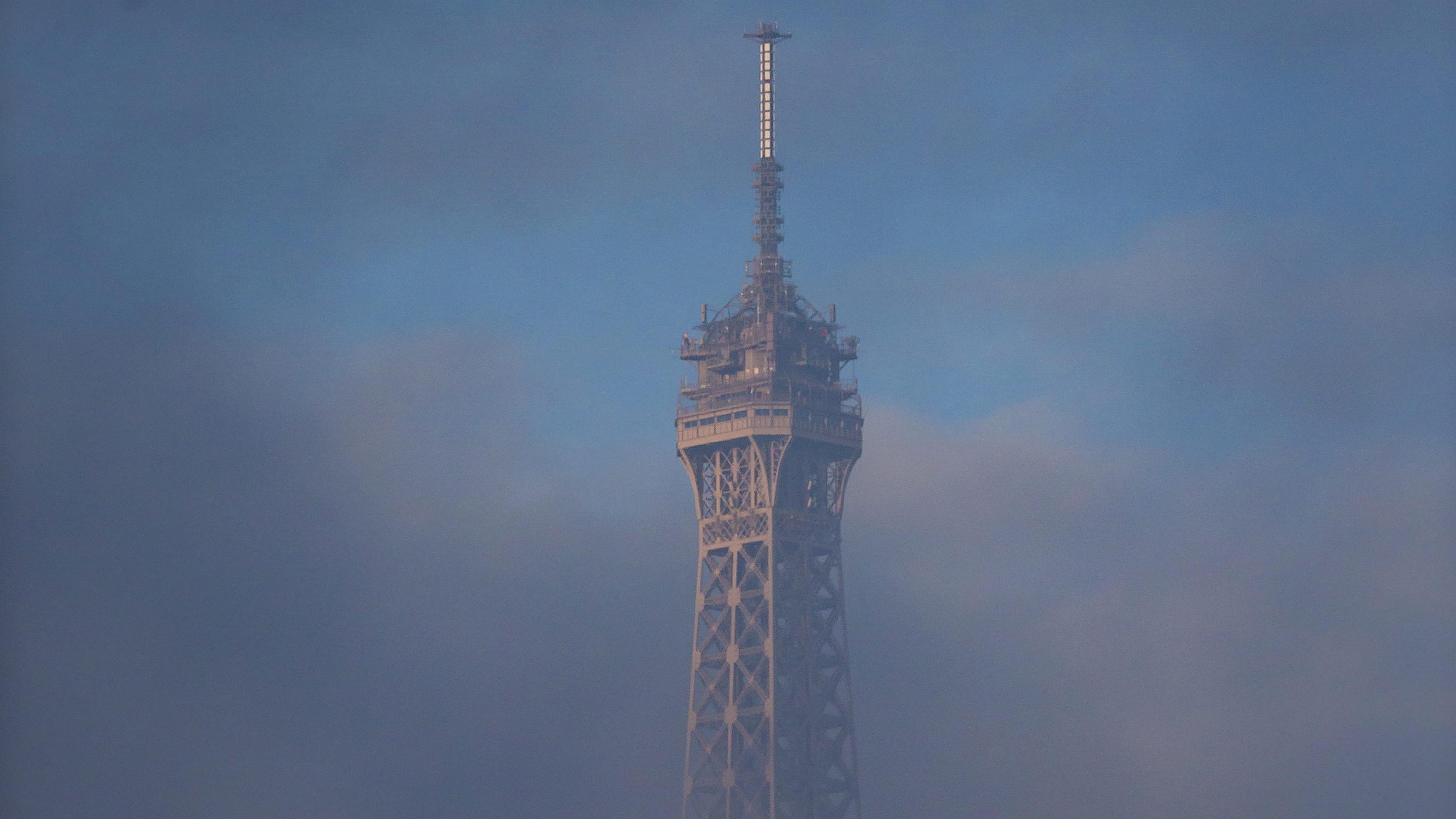 Unwetter Deutschland: Unfälle und Behinderungen durch Schneetief Bianca ARCHIV - 27.11.2015, Frankreich, Paris: Die Spitze vom Eiffelturm ragt aus tiefhängenden Wolken. (zu 130 Jahre Eiffelturm) Foto: Ian Langsdon/EPA/dpa +++ dpa-Bildfunk +++