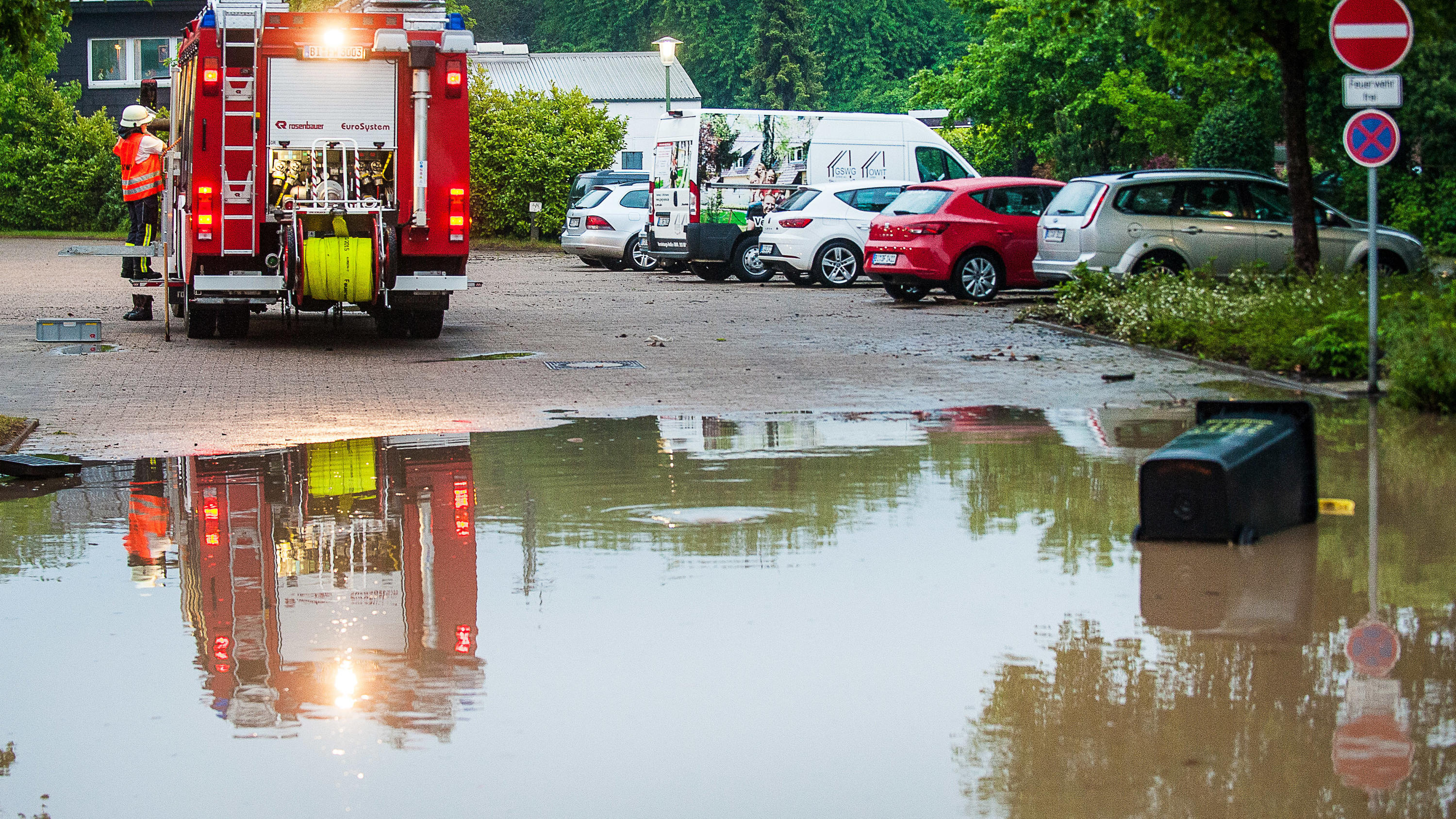 Krasse Unwetter: Krankenhaus evakuiert - 1 Toter durch Aquaplaning 20.05.2019, Nordrhein-Westfalen, Bielefeld: Ein Fahrzeug der Feuerwehr steht an einem überschwemmten Straßenstück. Tief «Axel» hat am Dienstagmorgen auch in Nordrhein-Westfalen für starke Regenfälle gesorgt. Wie der Deutsche Wetterdienst mitteilte, l