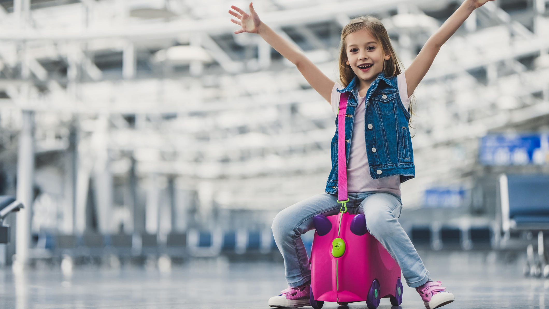 Packliste für den Sommerurlaub: Einfach abhaken, Koffer packen, relaxen! Das Gepäck ist aufgegeben und das kleine Mädchen ist bereit, mit seinem Handgepäck, den Flieger zu besteigen