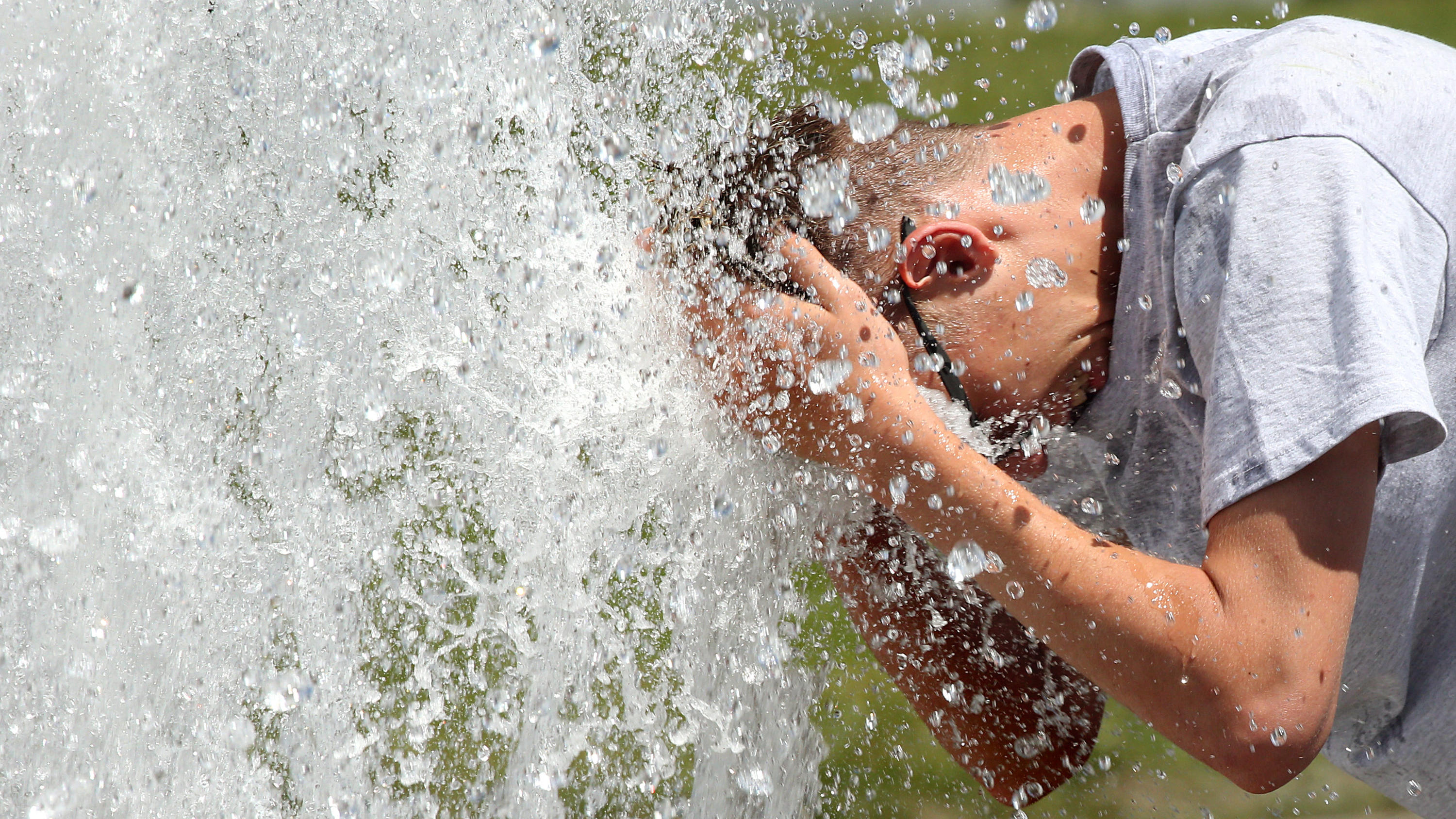 Sommerbilanz: Hitzerekorde, Trockenheit & Unwetter - Der Sommer 2019 war der Drittwärmste 24.06.2019, Berlin: Bei Temperaturen um 29 Grad Celsius erfrischt sich ein junger Mann im Berliner Lustgarten am Wasser eines Brunnens. In den kommenden Tagen sollen die Temperaturen weiter steigen. Foto: Wolfgang Kumm/dpa +++ dpa-Bildfunk +++