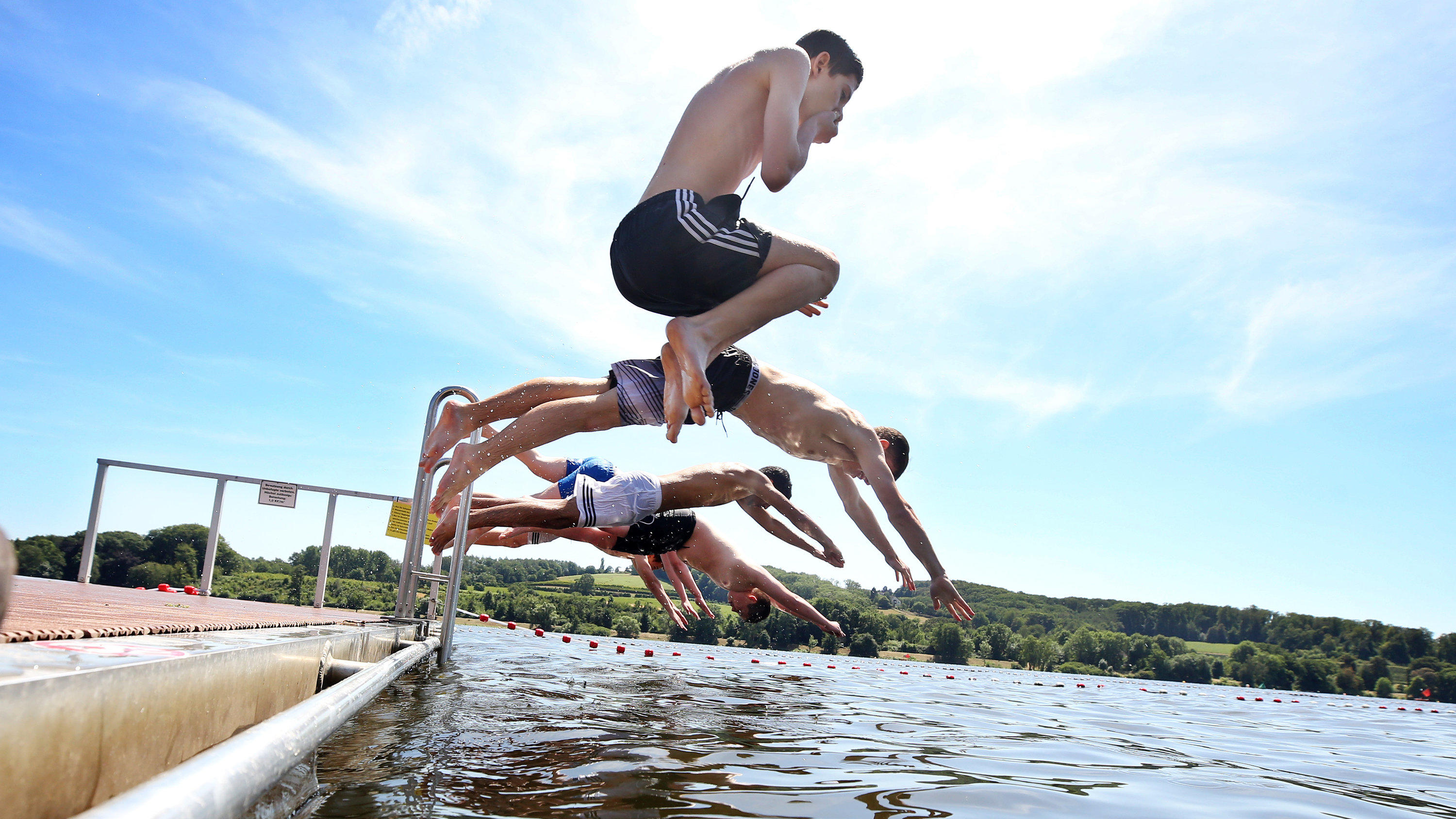 7-Tage-Trend: Der Sommer nimmt wieder Anlauf 04.07.2019, Nordrhein-Westfalen, Essen: Mit einem Sprung ins Wasser holen sich Schüler des Gymnasiums Überruhr eine Abkühlung im Baldeneysee. Das sommerliche Wetter mit Temperaturen bis 30 Grad soll in NRW weiter anhalten. Foto: Roland Weihrauch/dpa