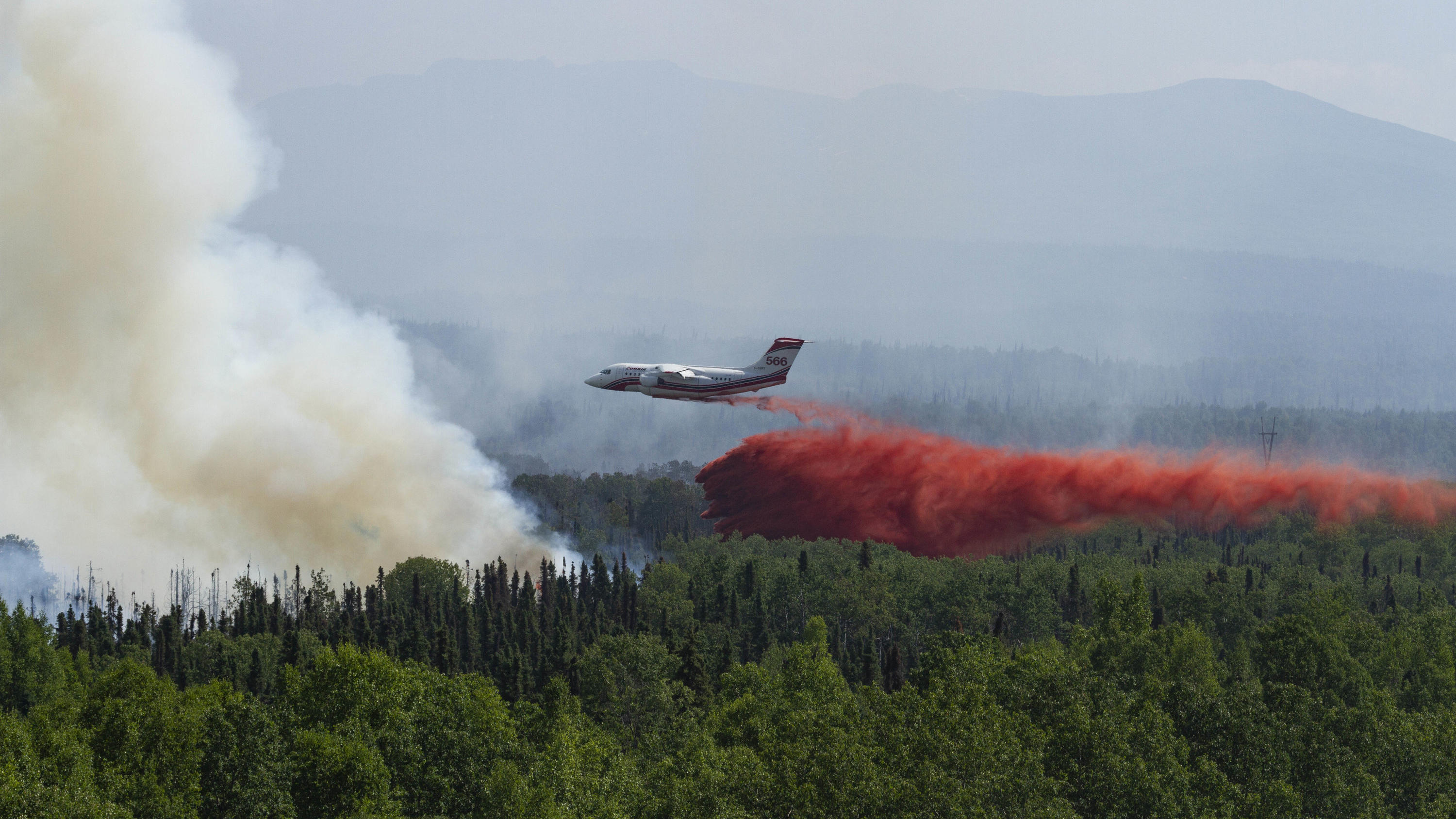 Arktische Hitzewelle: Temperaturrekorde und Waldbrände in Kanada, Alaska und Sibirien 04.07.2019, USA, Talkeetna: Ein Conair AVRO RJ85 AT Flugzeug lässt feuerhemmendes Mittel auf einem Lauffeuer in der Nähe des Montana Creek, fallen. Der nördlichste US-Bundesstaat Alaska ist für seine Gletscher und eher kühle Temperaturen bekannt, doc