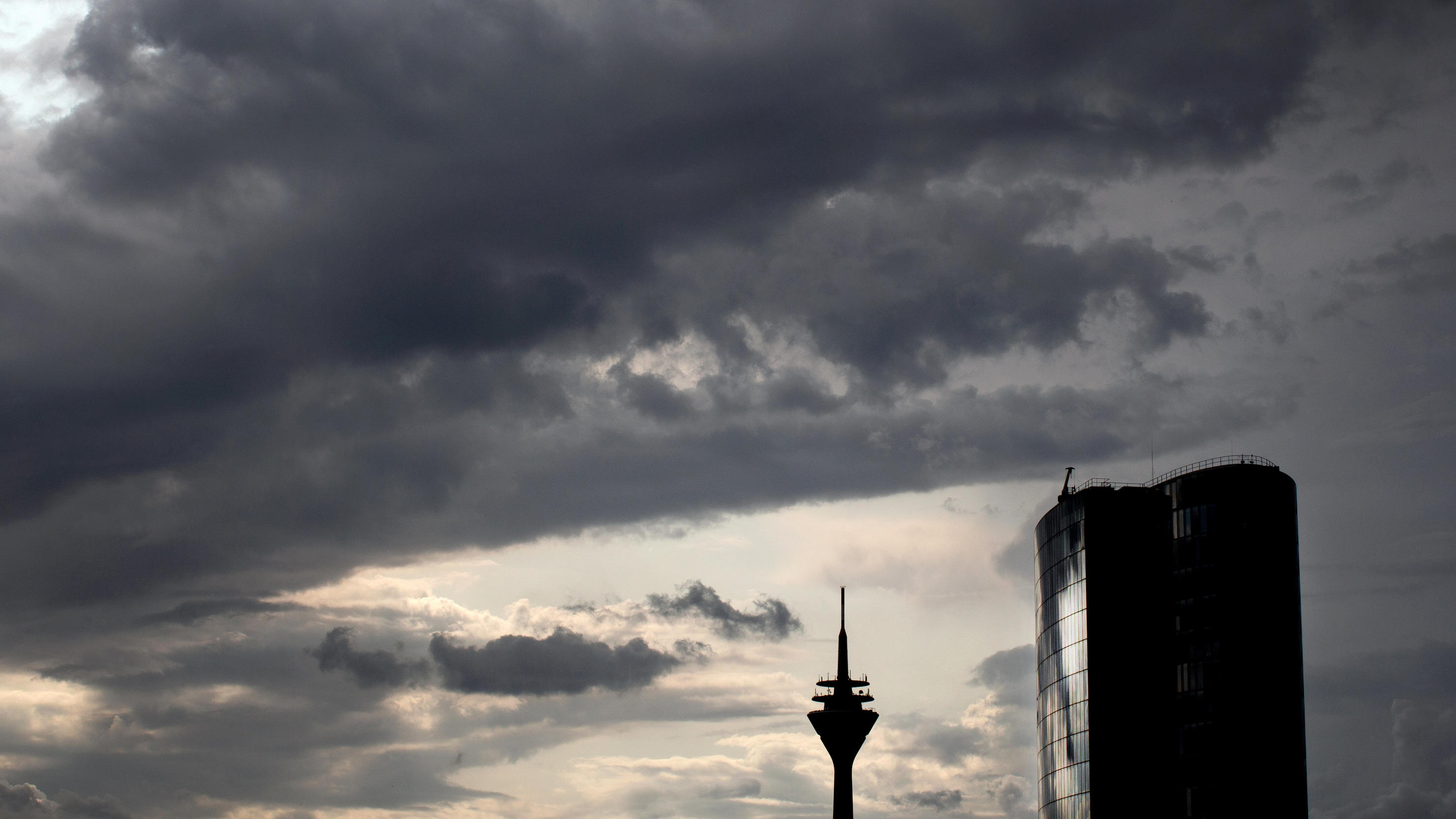 Hochsommerphase in Deutschland beendet – Hitze in Südeuropa mit über 30 Grad 02.08.2019, Düsseldorf: Wolken ziehen über den Rheinturm und das Hochhaus GAP 15 in Düsseldorf. Foto: Martin Gerten/dpa +++ dpa-Bildfunk +++