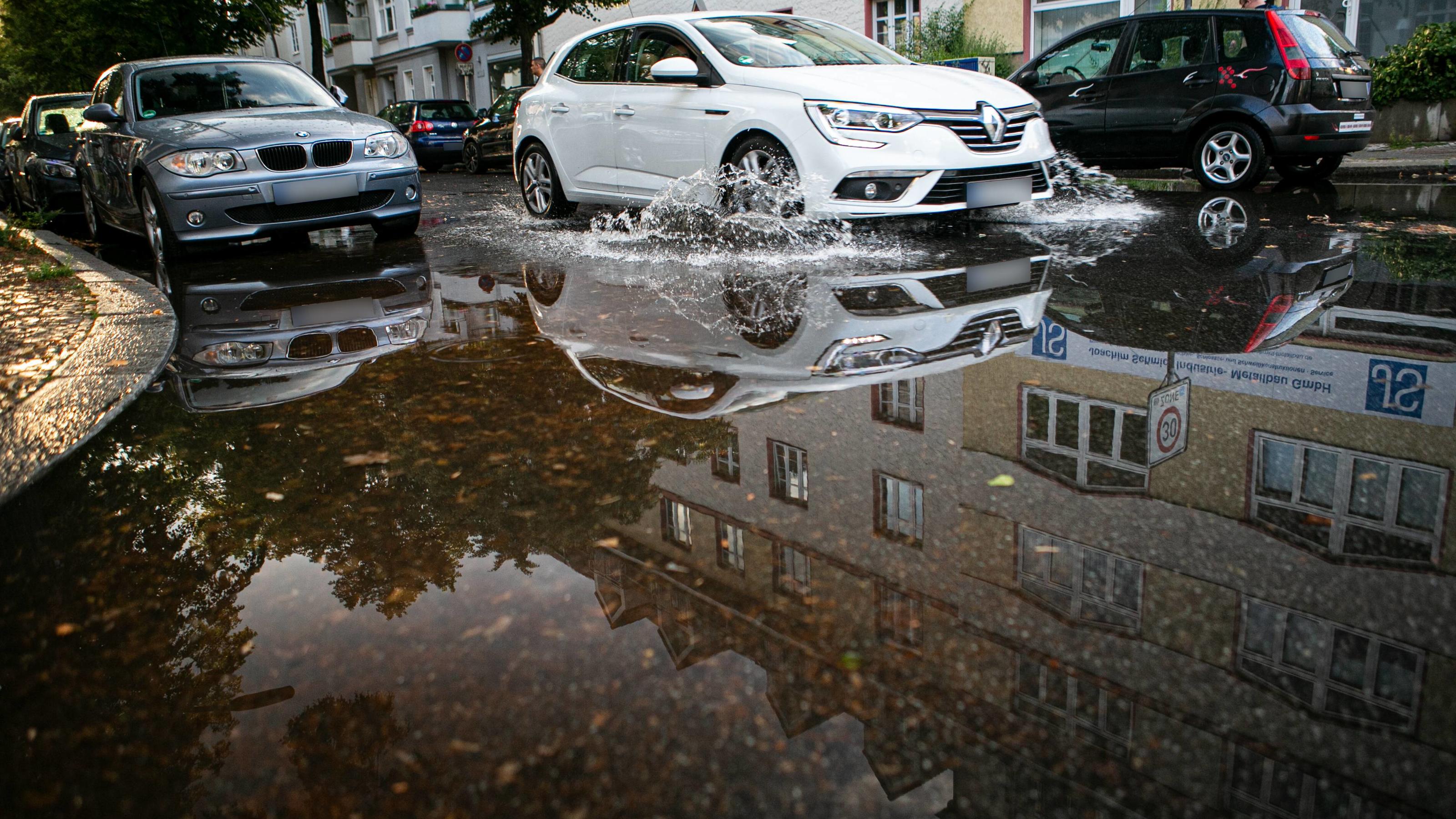 Unwettergefahr im Süden Deutschlands: Gewitter und Dauerregen noch bis Mittwoch erwartet Regenschauer sorgt für Oberflächenwasser, Fahrbahn wird durch einen kräftigen Regenschauer überflutet. Berlin Tempelhof Deutschland *** Rain shower provides surface water, roadway is flooded by a heavy rain shower Berlin Tempelhof Germany