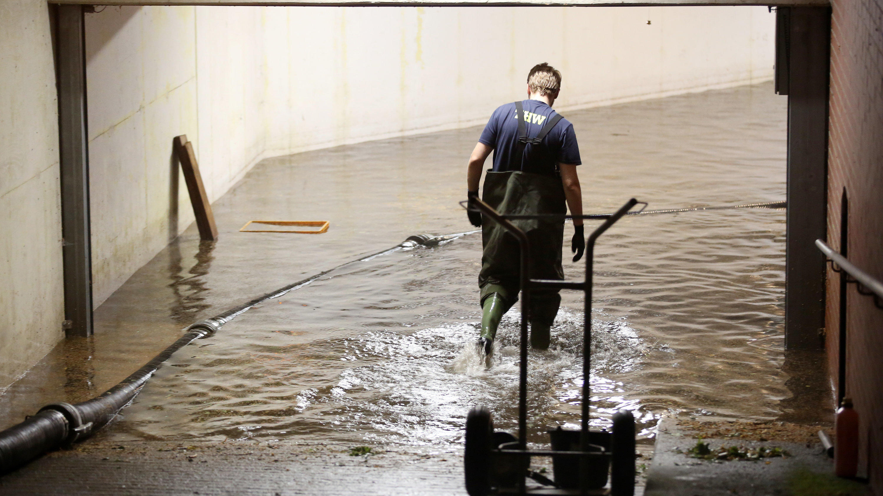 Unwetter Deutschland: Heftige Hitzegewitter über Deutschland 27.08.2019, Hamburg: Ein THW-Mitarbeiter geht nach Starkregen am späten Abend im Stadtteil Niendorf in eine voll gelaufenen Tiefgarage, die mit einer Pumpe leergepumpt wird. Nach Angaben eines THW-Gruppenführers wird das Leerpumpen der Garage mehrere