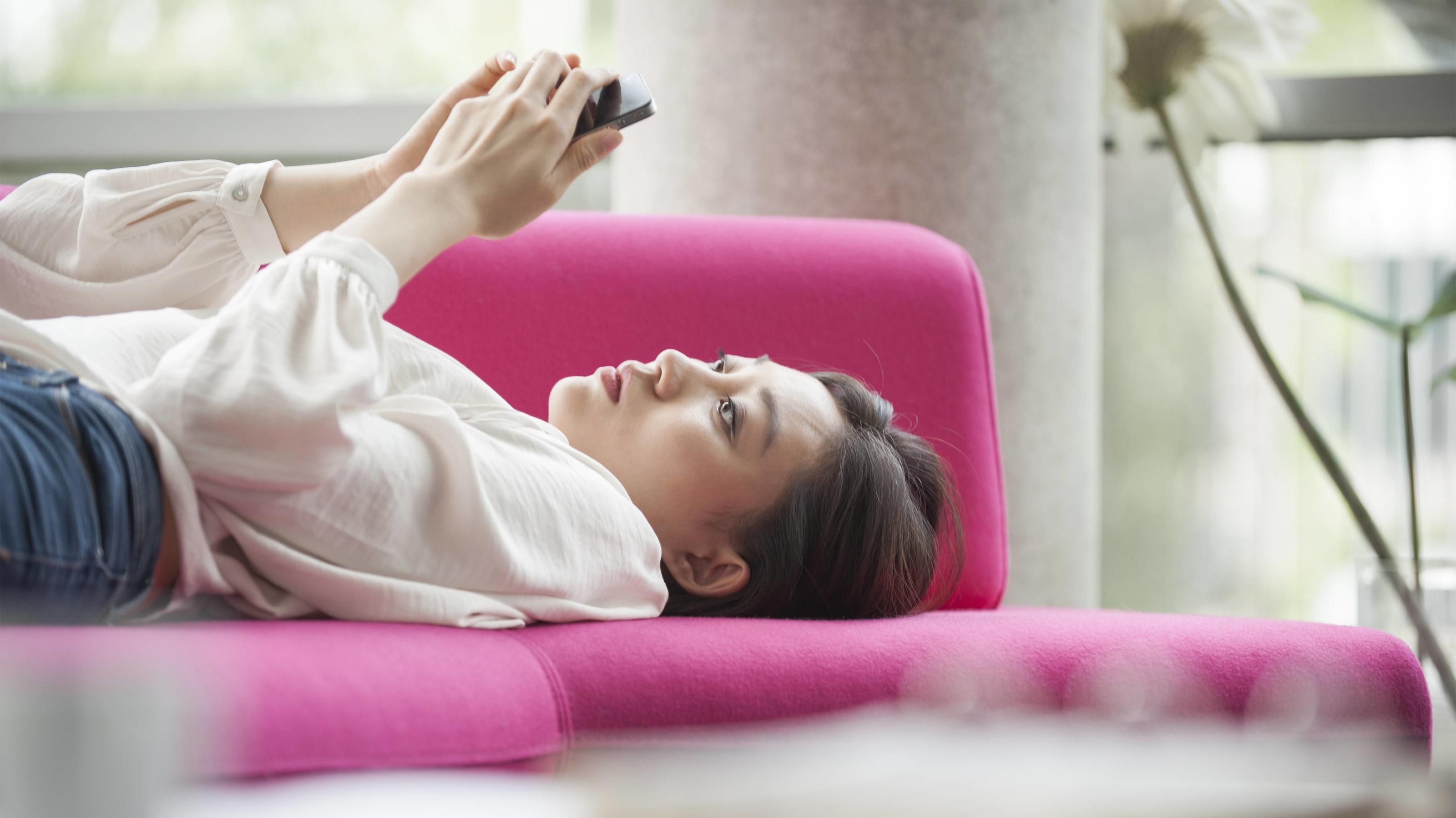 Wir Deutschen verlernen das Genießen Woman relaxing at home using smartphone PUBLICATIONxINxGERxSUIxAUTxONLY Copyright: OdilonxDimier B27279227