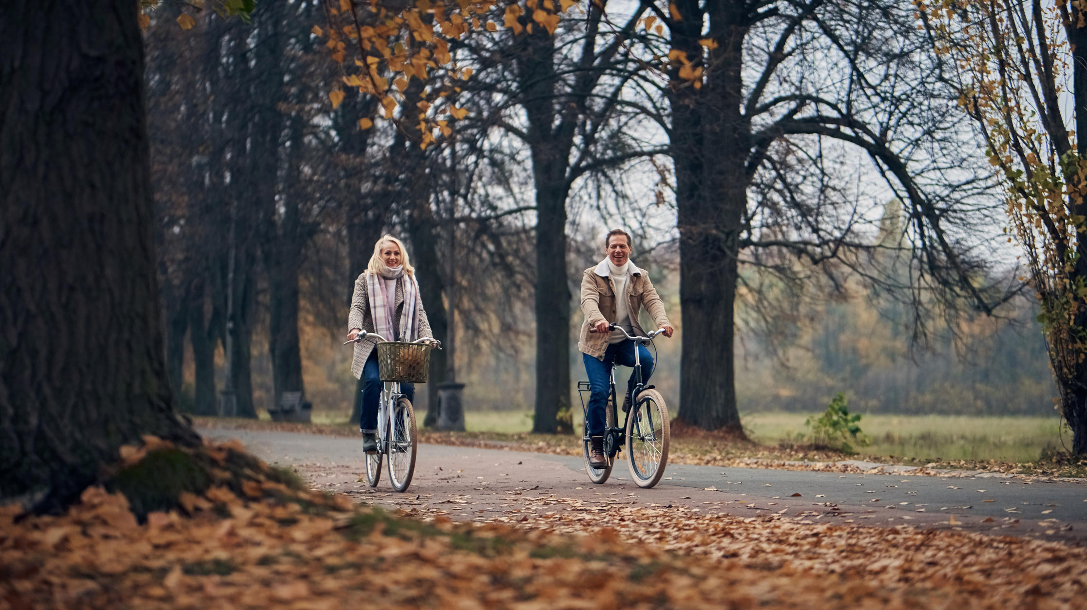 Radfahren im Herbst: So radelt man sicher durch die kalte Saison Paar fährt Rad im Park