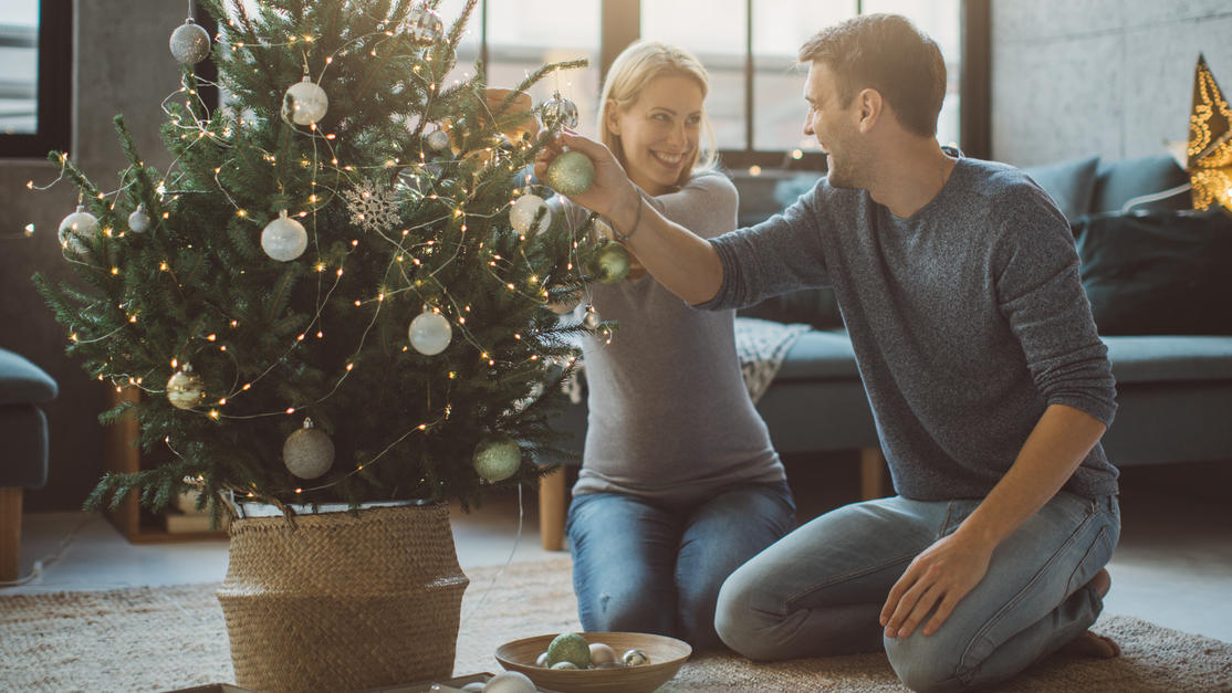 5 Adventskalender-Ideen für Schwangere und frisch gebackene Muttis Schwangere Frau schmückt Weihnachtsbaum