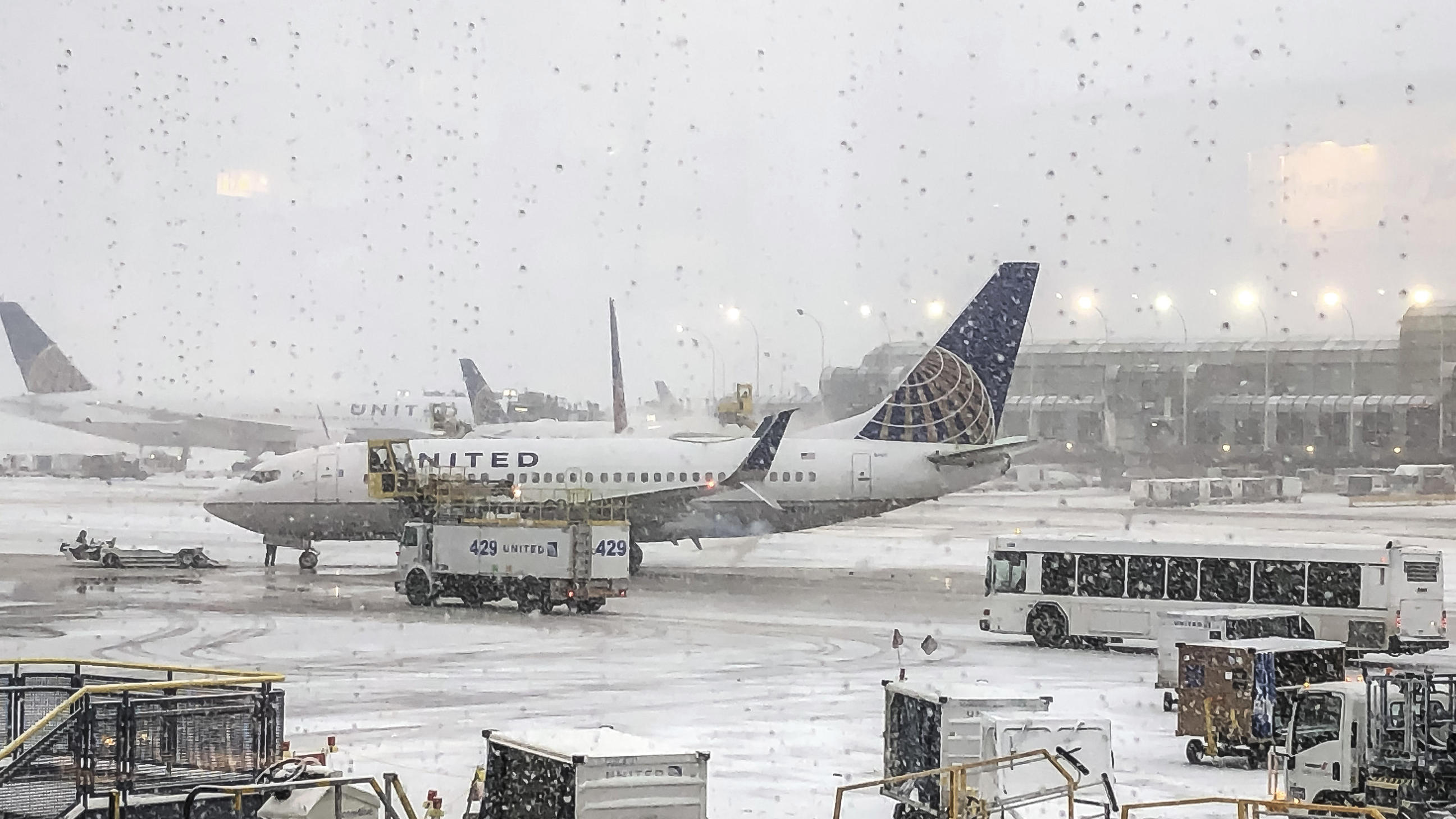 Schockmoment in Chicago: Flugzeug rutscht von vereister Landebahn Schnee fällt auf das United Terminal am O'Hare Airport. Heftiger Schneefall hat in Chicago zu Hunderten Flugausfällen geführt. Der größte internationale Flughafen O'Hare war am Montag besonders betroffen.