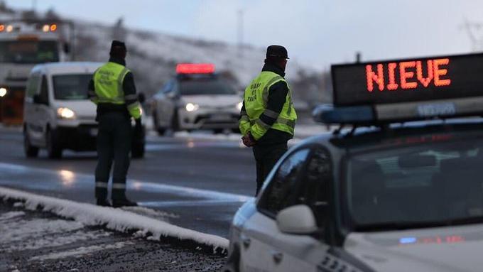 Frühwinter in Spanien sorgt für Straßenchaos 14.11.2019, Spanien: Zwei Beamte der Zivilgarde überwachen den Einsatz von Schneeketten in einem verschneiten Gebiet. In weiten Teilen Spaniens hat eine Kaltfront für einen frühen Einzug des Winters und erste Schneefälle gesorgt.