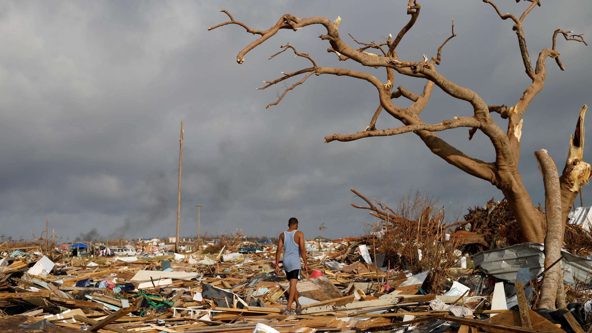2010 bis 2019: Ein Jahrzehnt der Wetterextreme FILE PHOTO: A man walks among debris at the Mudd neighborhood, devastated after Hurricane Dorian hit the Abaco Islands in Marsh Harbour, Bahamas, September 6, 2019. REUTERS/Marco Bello/File Photo