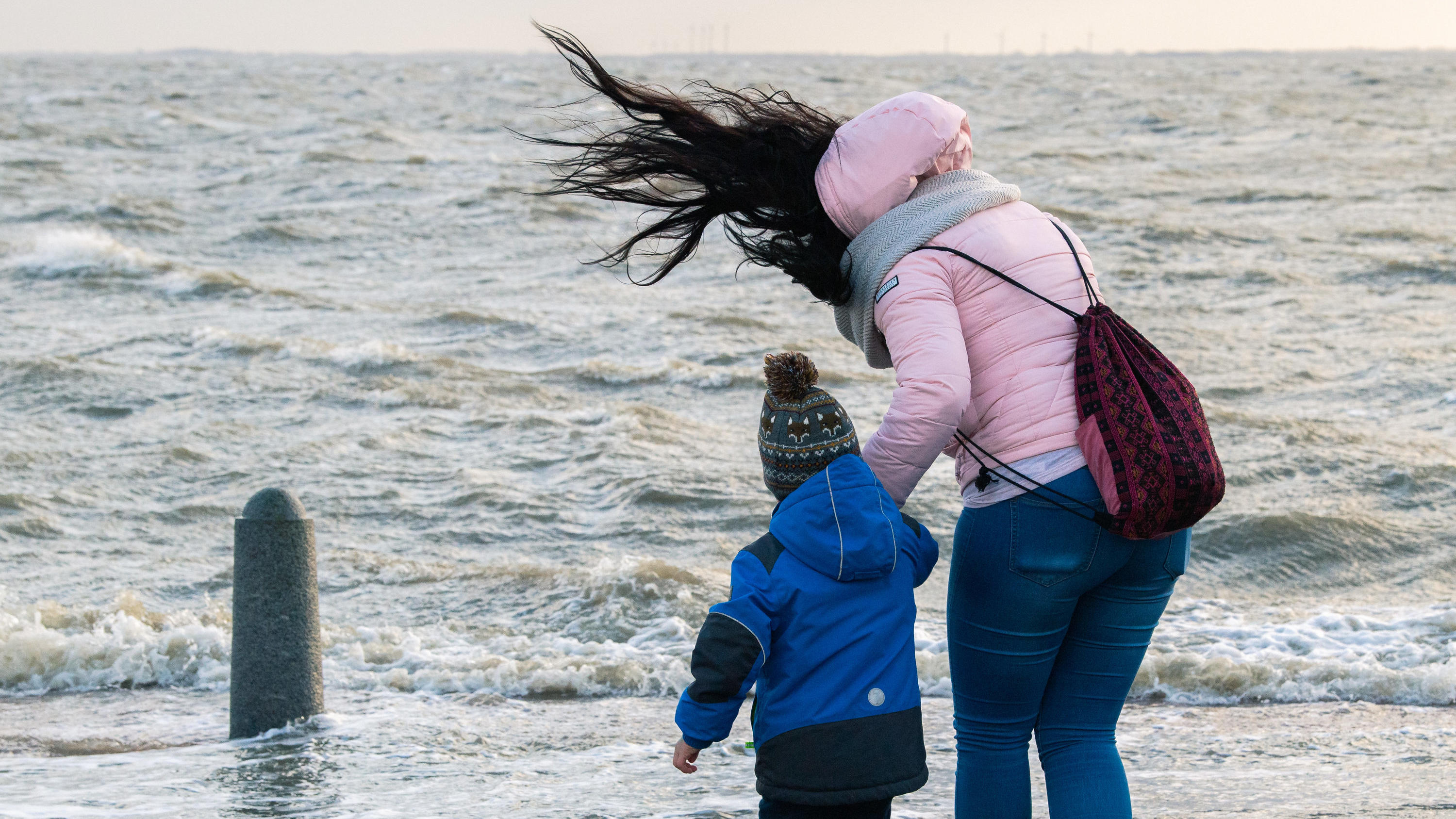 Sturmtief 15.12.2019, Niedersachsen, Wilhelmshaven: Während des stürmischen Wetters ist der 4-jährige Julien mit seiner Mutter Lisa am Ufer der Nordseeküste von Wilhelmshaven. Foto: Mohssen Assanimoghaddam/dpa +++ dpa-Bildfunk +++
