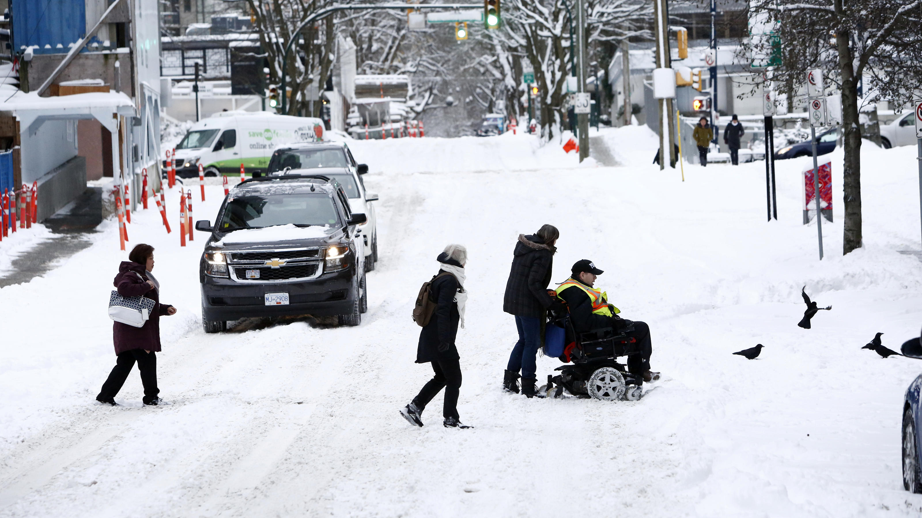 Arktischer Winter fällt über Nordamerika herein Pedestrians help a man who uses a wheelchair cross the street after a snow storm in downtown Vancouver, British Columbia, Canada January 15, 2020. REUTERS/Jesse Winter