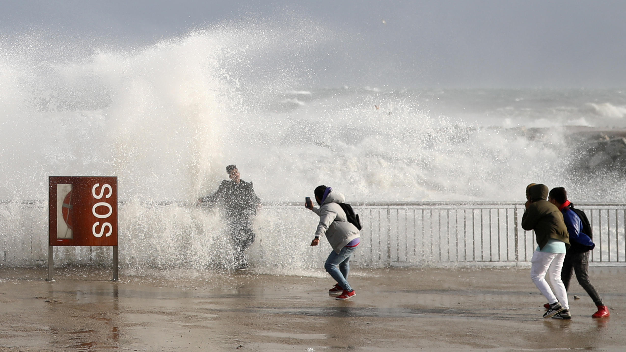 Klimawandel lässt Monsterwellen höher schlagen Tourists take a pictures as sea waves cover them during the storm