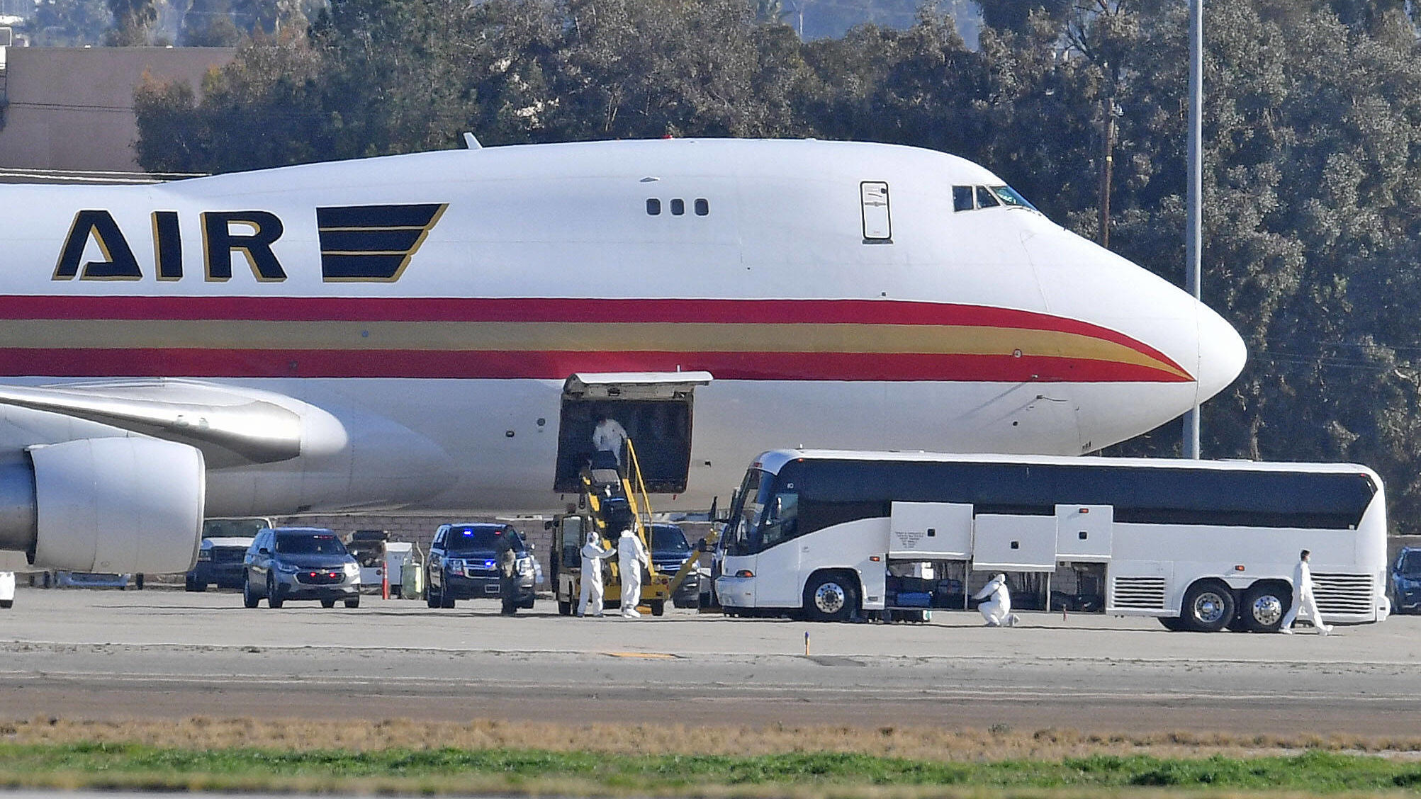 Coronavirus-Chronik Teil 1 January 29, 2020, Riverside, California, USA: A team in white biohazard suits unload luggage off a charter flight from Wuhan, China, carrying approximately 200 U.S. citizens, after landing at March Air Reserve Base in Riverside, Calif. Wednesday morn