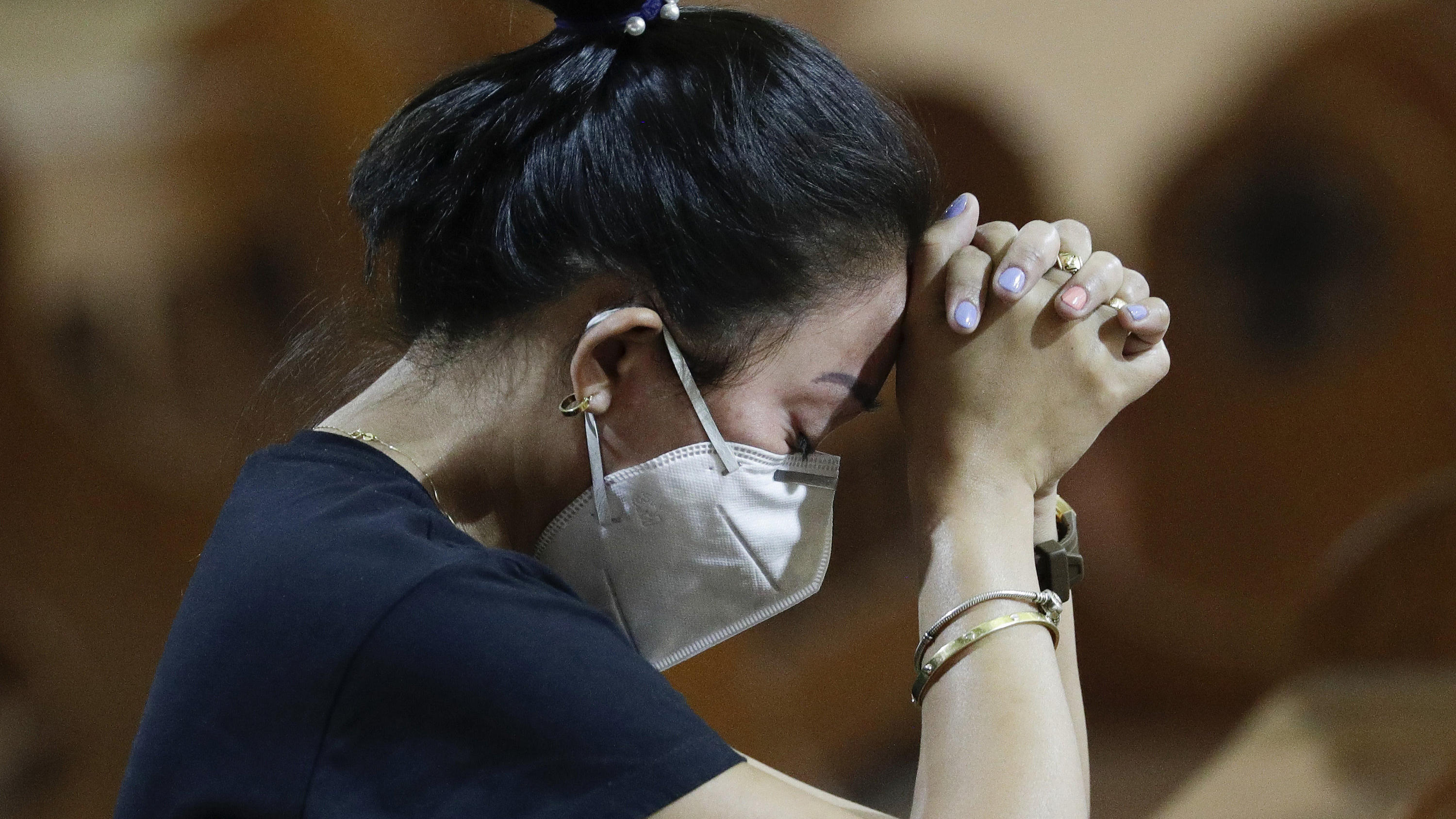 Coronavirus-Chronik Teil 1 30.01.2020, Philippinen, Manila: Eine Frau mit Atemschutzmaske betet während einer Messe. Die Zahl der Infektionen und Todesopfer durch die Lungenkrankheit aus China ist weltweit erneut gestiegen. Foto: Aaron Favila/AP/dpa +++ dpa-Bildfunk +++