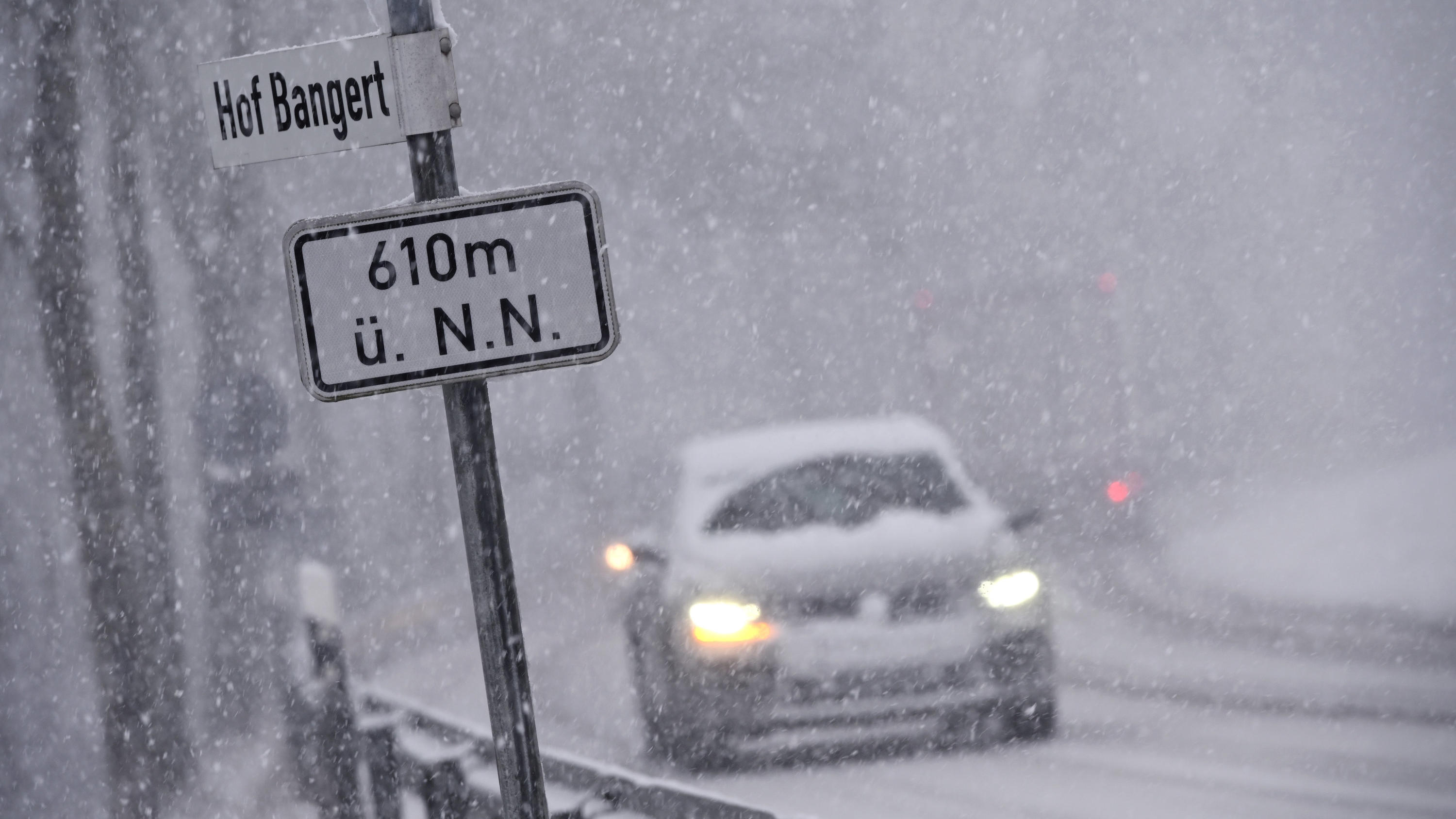 Hochwasser-Ticker: Die Hochwasser-Pegel am Rhein steigen weiter 04.02.2020, Hessen, Willingen: Bei starkem Schneefall fahren Autos über eine Straße bei Willingen. Ein Schild weist eine Höhe von 610 Metern über Normal Null aus. Foto: Uwe Zucchi/dpa +++ dpa-Bildfunk +++