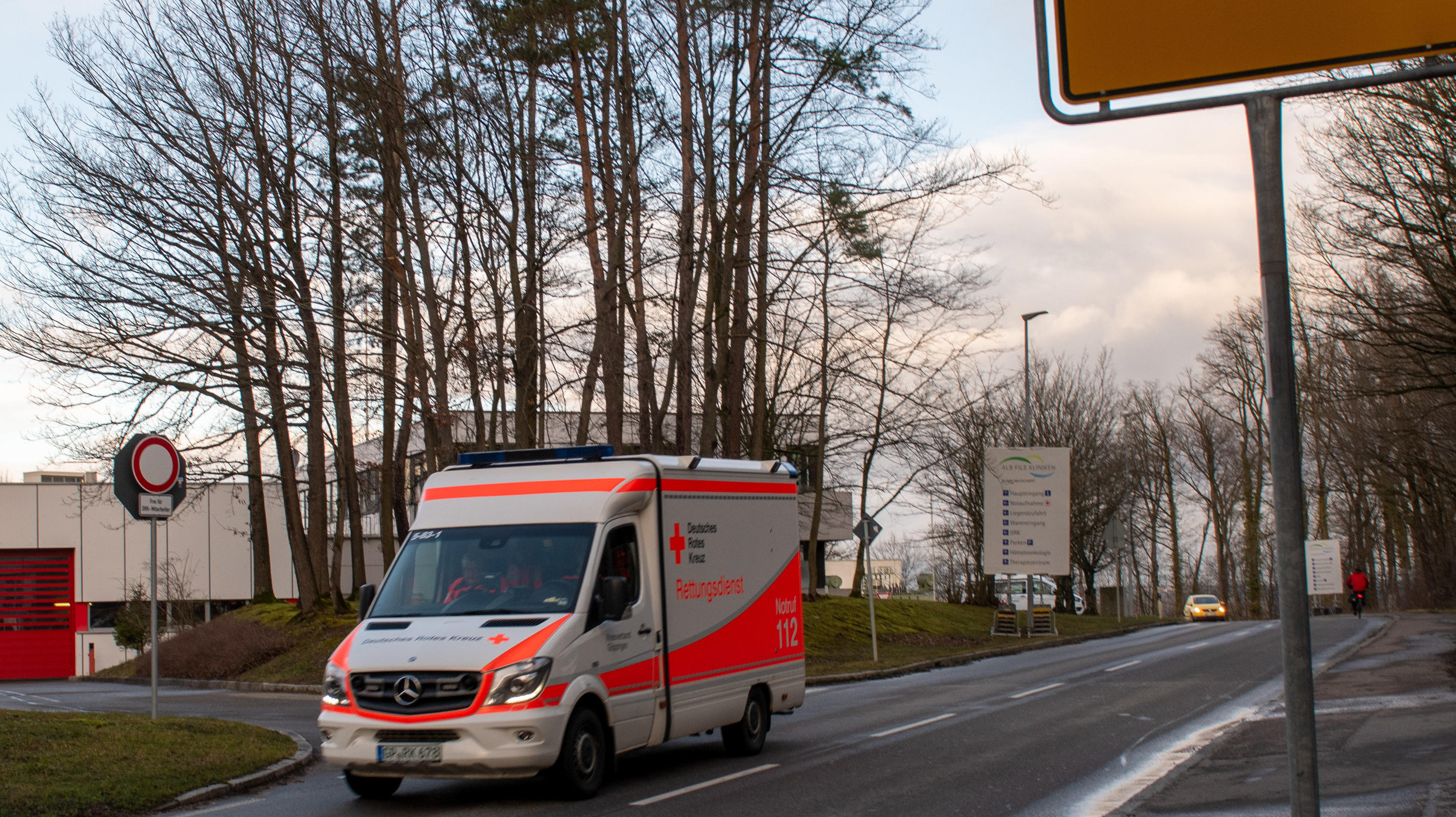 Coronavirus aus China: Chronik der bisherigen Ausbreitung - Teil 5 26.02.2020, Baden-Württemberg, Göppingen: An der Klinik am Eichert fährt ein Rettungswagen am Ortsschild von Göppingen vorbei. In Göppingen wurde der erste Coronakranke in Baden-Württemberg bestätigt. Foto: Stefan Puchner/dpa +++ dpa-Bildfunk +++