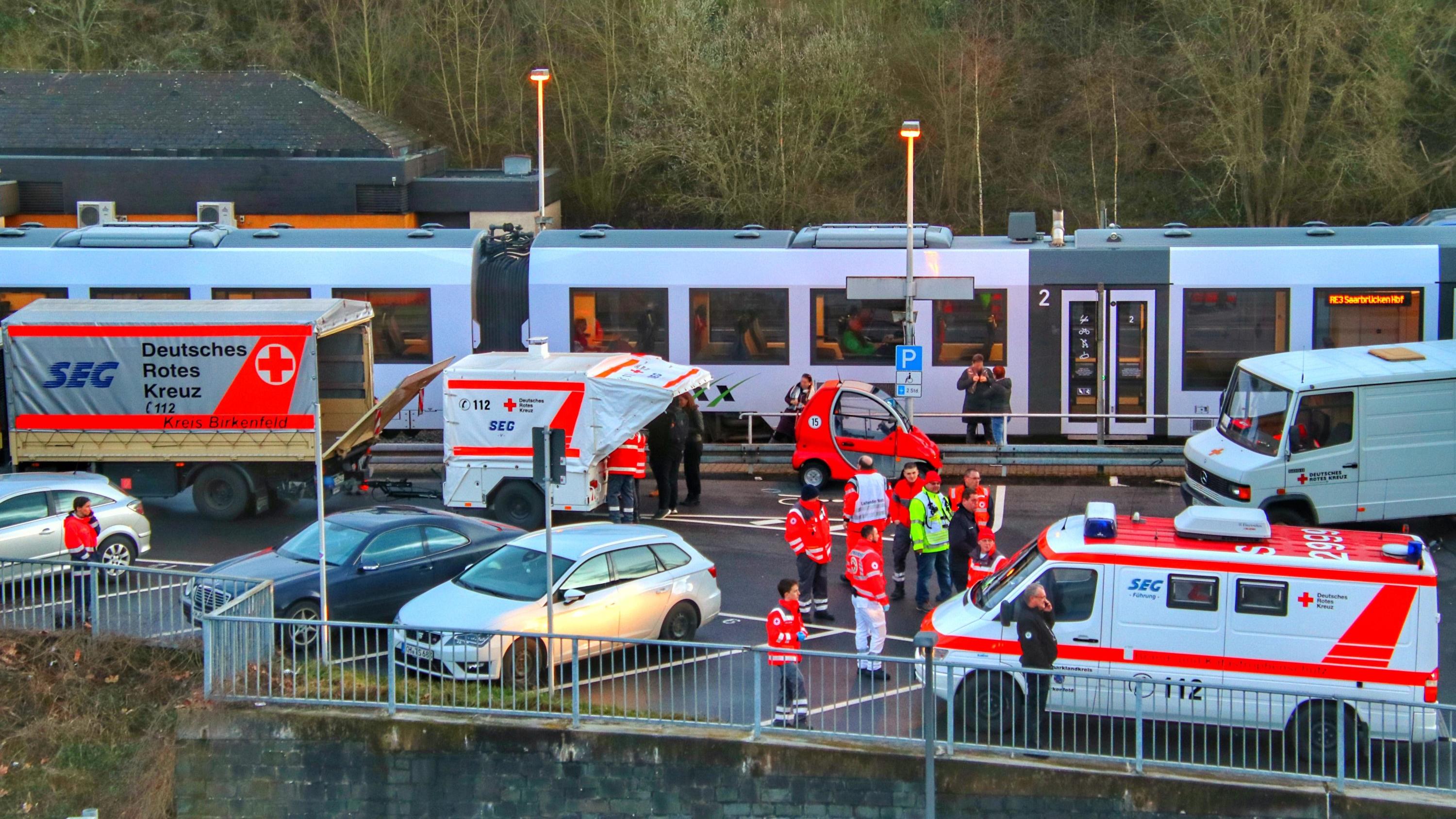 Coronavirus aus China: Chronik der bisherigen Ausbreitung - Teil 5 26.02.2020, Rheinland-Pfalz, Idar-Oberstein: Rettungssanitäter stehen am Bahnhof. Die Bundespolizei in Idar-Oberstein hatte hier einen Regionalzug mit etwa 70 Fahrgästen wegen Coronavirus-Verdachts gestoppt. Es habe einen Hinweis gegeben, dass ein Re