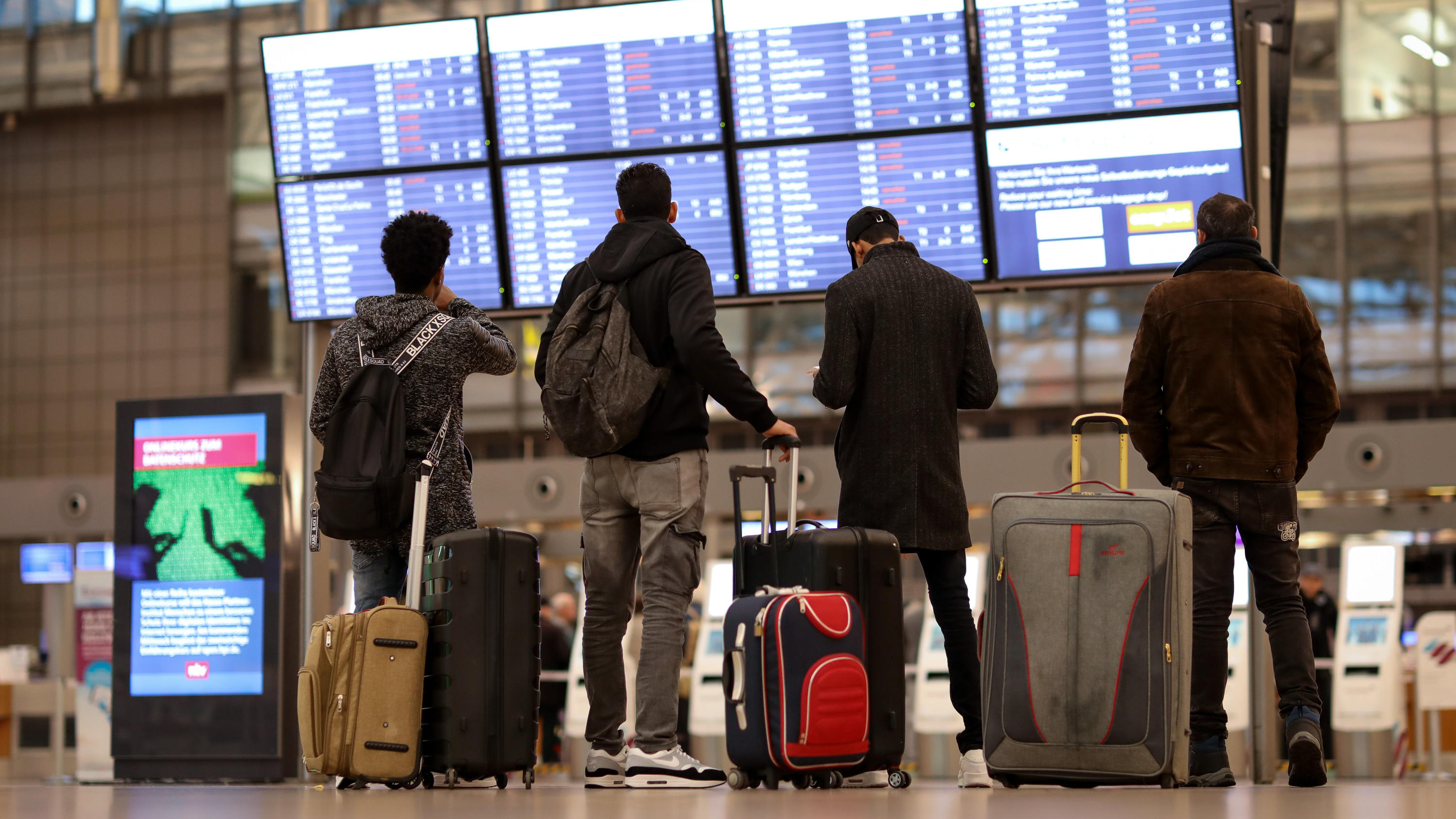 Coronavirus aus China: Chronik der bisherigen Ausbreitung - Teil 5 ARCHIV - 15.01.2019, Hamburg: Fluggäste stehen vor einer Anzeigetafel im Terminal 1 des Flughafens Hamburg. Vor dem Urlauberansturm an diesem Wochenende hat der Hamburger Flughafen seine Maßnahmen gegen die Ausbreitung des neuartigen Coronavirus vers