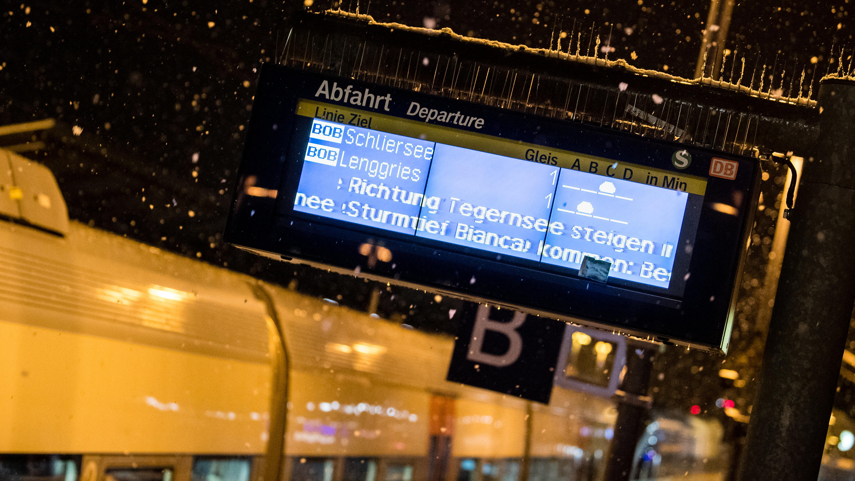 Unwetter Deutschland: Unfälle und Behinderungen durch Schneetief Bianca 27.02.2020, Bayern, Holzkirchen: Auf einer Infotafel am Bahnhof von Holzkirchen wird im Schneegestöber auf Beeinträchtigungen durch Sturmtief Bianca hingewiesen. Aufgrund von Sturmtief Bianca wird der Zugverkehr zwischen Holzkirchen und Rosenheim in