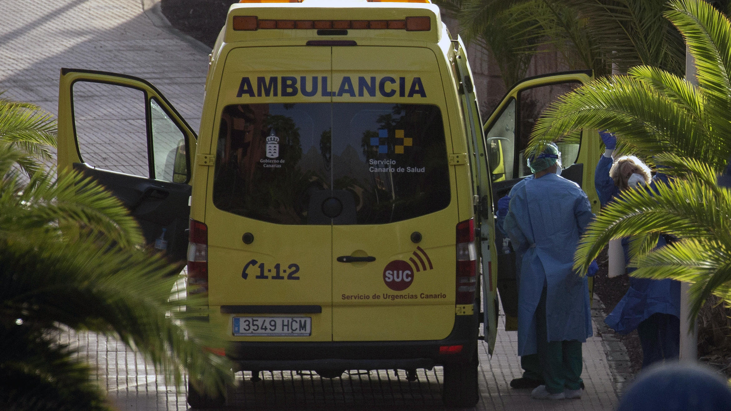 Coronavirus aus China: Chronik der bisherigen Ausbreitung - Teil 5 29.02.2020, Spanien, Santa Cruz de Tenerife: Eine Gästin (r) aus dem Hotel H10 Costa Adeje Palace winkt, bevor sie in einem Krankenwagen transportiert wird. Einige der Gäste des unter Quarantäne gestellten Hotels auf Teneriffa haben das Gebäude mit E