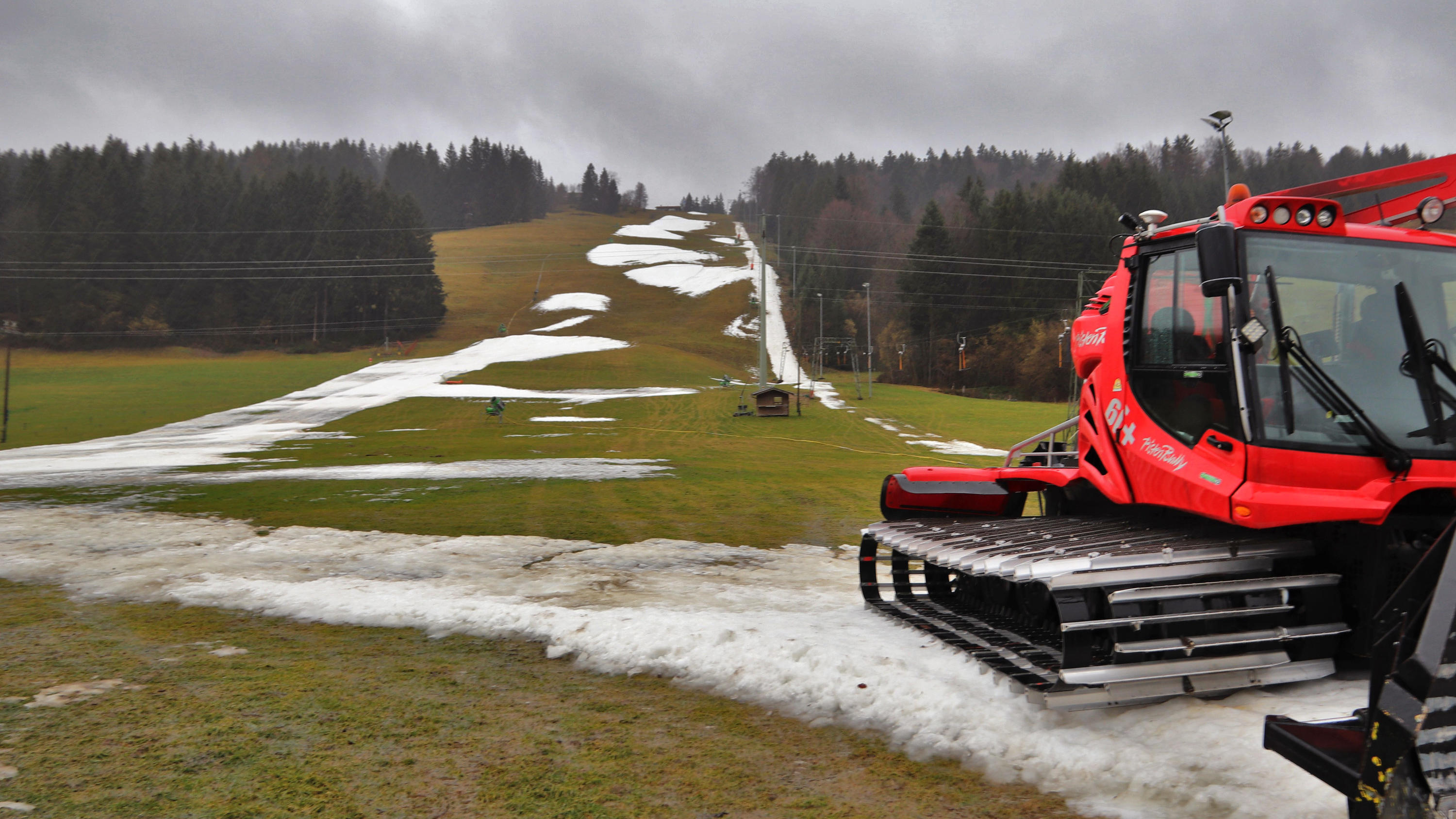 Winter 2019/2020: So viel Schnee wie seit Jahren nicht ARCHIV - 03.02.2020, Bayern, Thalkirchdorf: Eine Pistenraupe steht auf einer Skipiste, die bei Tauwetter noch teilweise mit Schneeresten bedeckt ist. (Zu dpa