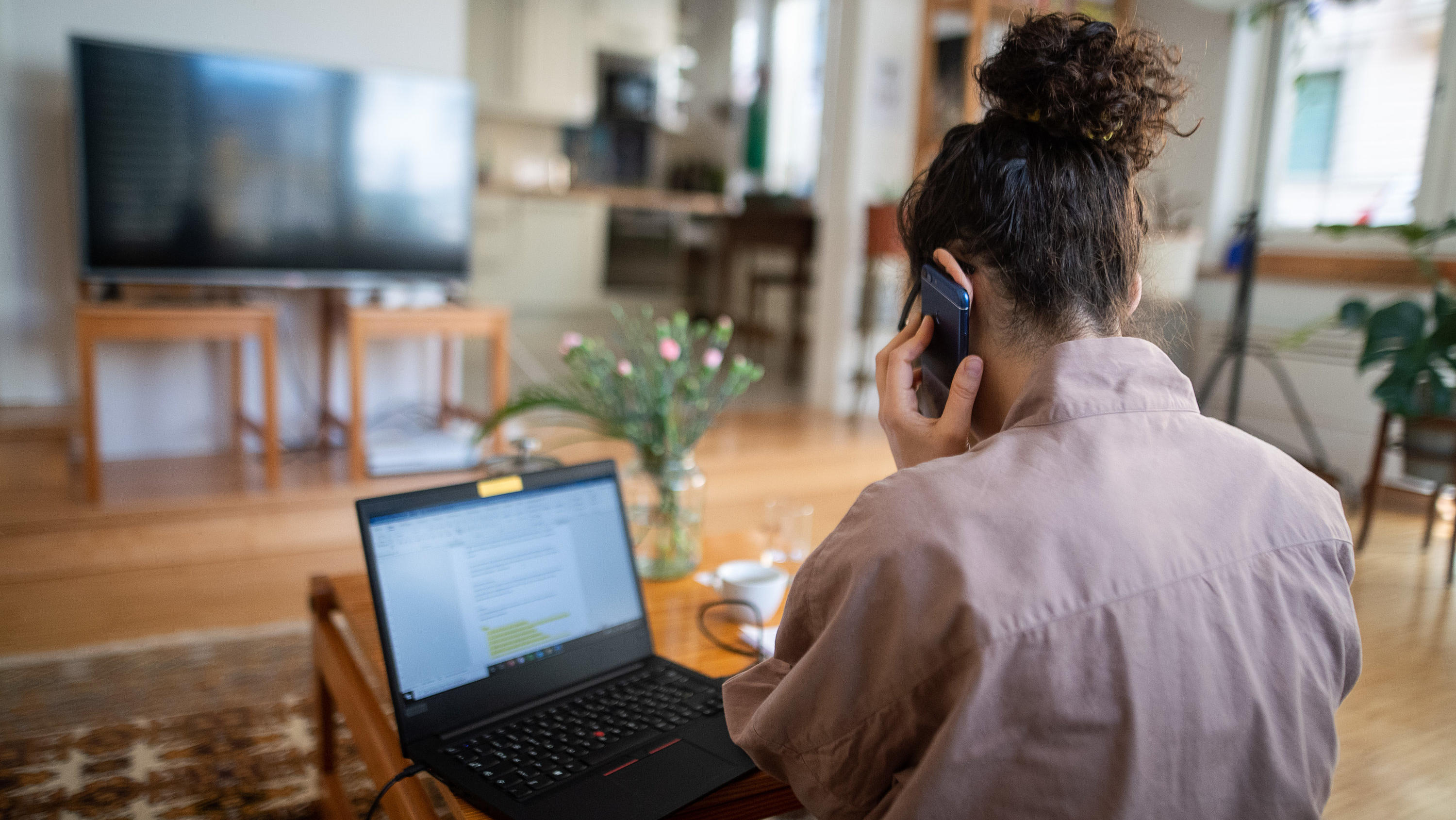 Digital in der Coronakrise - Wie klimafreundlich ist Homeoffice? 18.03.2020, Baden-Württemberg, Stuttgart: Eine Frau nimmt aufgrund der Ausbreitung des Coronaviruses aus ihrem Wohnzimmer an einer Telefonkonferenz teil. Foto: Sebastian Gollnow/dpa +++ dpa-Bildfunk +++