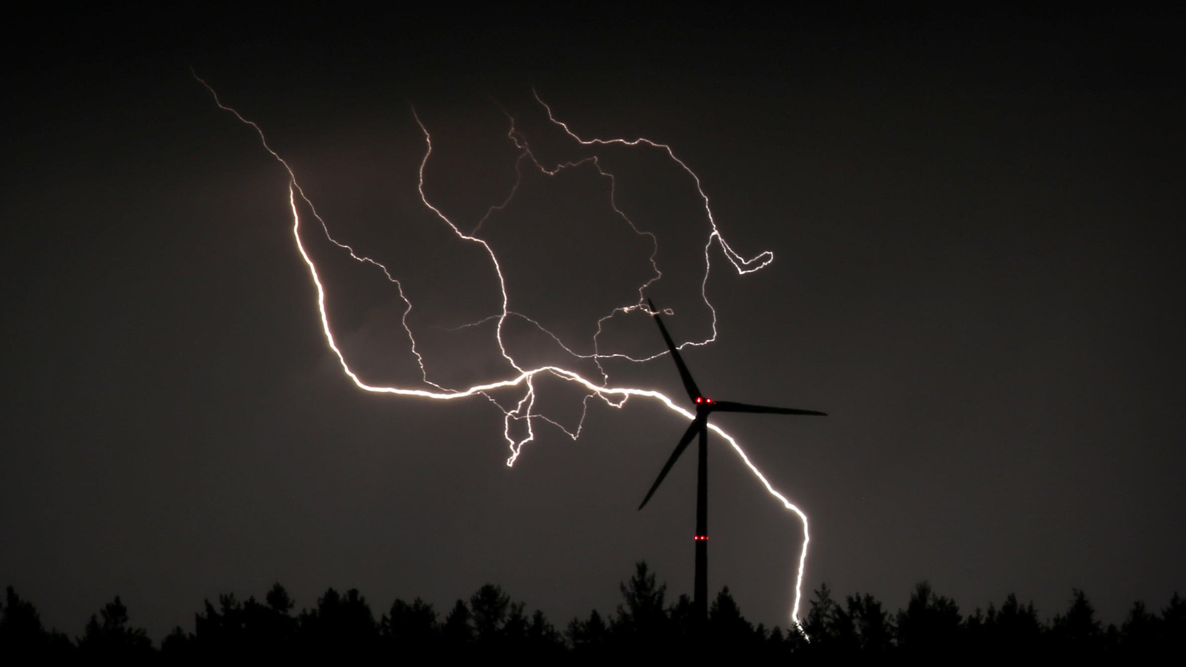Tiefdruck-Trio schlägt Dauerhoch 20.03.2020, Bayern, Bidingen: Blitze entladen sich hinter einem Windrad. Foto: Karl-Josef Hildenbrand/dpa +++ dpa-Bildfunk +++