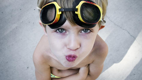 Freibad in Netphen öffnet, aber Kinder dürfen nicht rein Junge hat eine Badehose an und eine Taucherbrille auf dem Kopf. Er schaut schmollend und mit verschrenkten Armen in die Kamera.