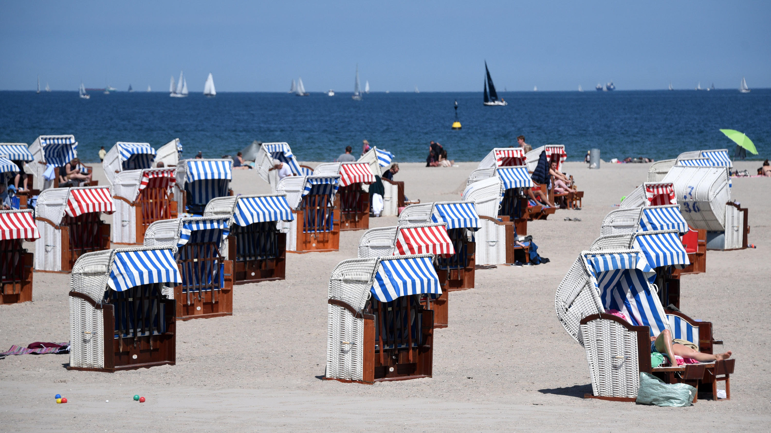 Wie werden die Abstands- und Hygieneregeln an deutschen Stränden umgesetzt? 21.05.2020, Schleswig-Holstein, Lübeck-Travemünde: Nur wenige Strandkörbe sind am Strand an der Ostsee besetzt. Aufgrund der Abstandsregeln während der Corona-Pandemie stehen die Strandkörbe auch einige meterweit von einander entfernt. Foto: Daniel B