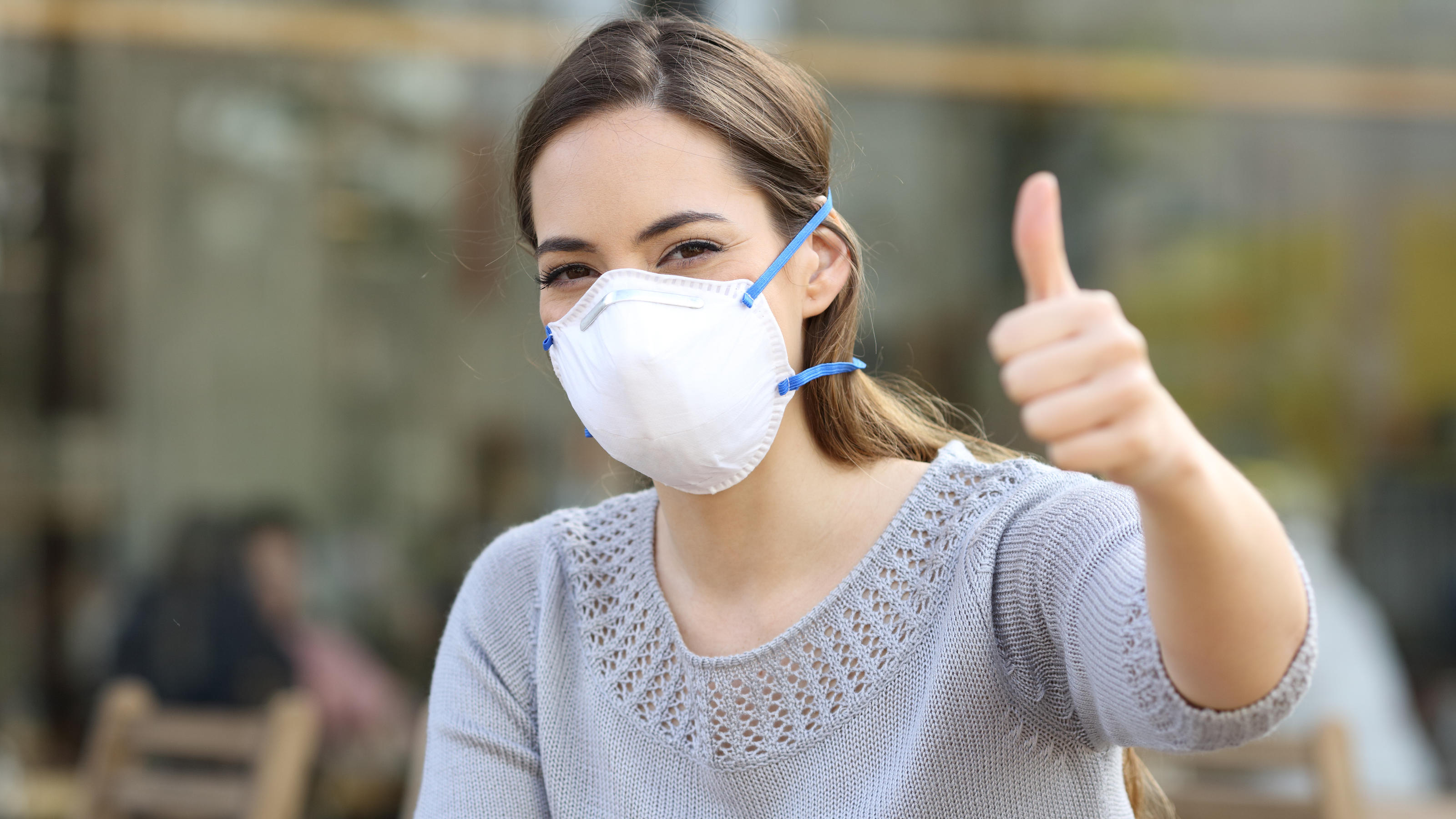 Coronavirus in Deutschland: In diesen Bundesländern liegen wir im grünen Bereich Frau mit Mundschutz zeigt Daumen hoch.