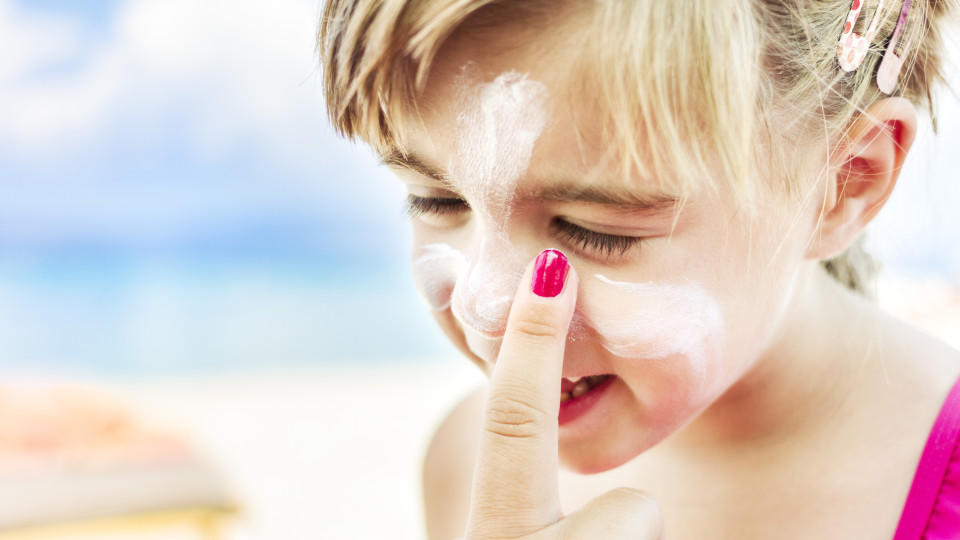 Günstiges Drogerie-Produkt ist besser als Naturkosmetik Shoot Planner Ref #107 - Beach lifestyle moments - Mother is applying a sunscreen to her daughter on the beach. Beautiful blue Aegean sea can be seen in the background. AdobeRGB profile.