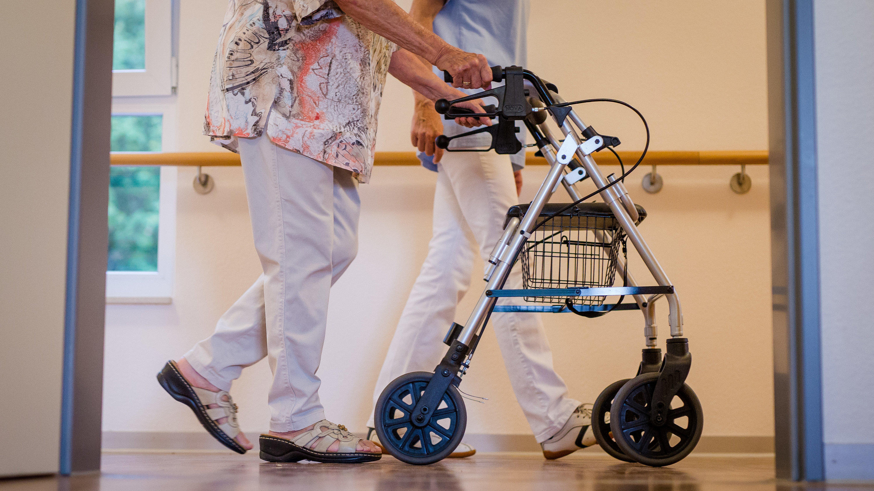 Das ändert sich zum 1. Juli für Verbraucher ARCHIV - 23.08.2018, Stuttgart: Eine Pflegekraft geht in einem Pflegeheim mit einer älteren Dame über einen Korridor. (zu dpa «AOK-Zahlen zur Pflege in Rheinland-Pfalz») Foto: Christoph Schmidt/dpa +++ dpa-Bildfunk +++