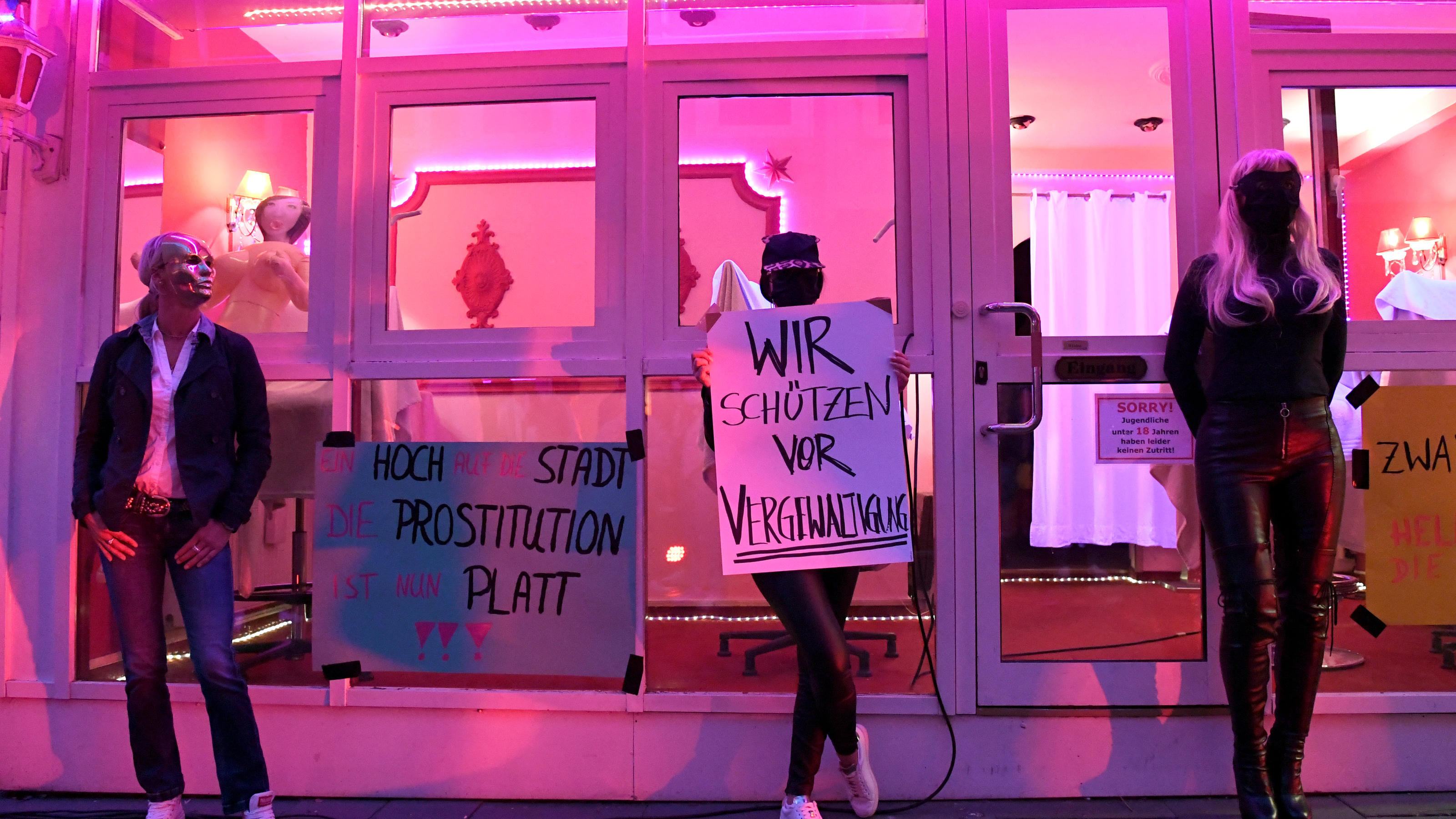 Prostituierte fordern auf der Reeperbahn Wiedereröffnung der Bordelle Prostitutes wearing masks hold signs reading