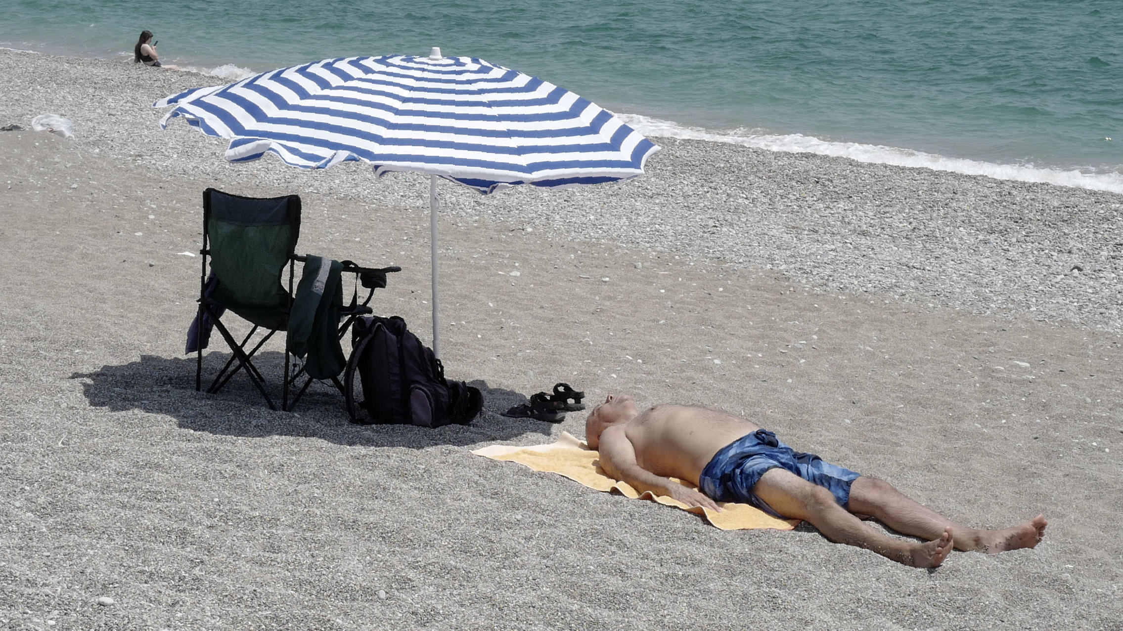 Bundesregierung hebt Reisewarnung für Türkei teilweise auf dpatopbilder - 27.07.2020, Türkei, Antalya: Ein Mann sonnt sich am Strand der Küste von Antalya, vor der «Oruc Reis», das Forschungsschiff der Türkei, ankert. Die Regierung von Griechenland begrüßte die Entscheidung der Türkei, auf die umstrittene Er