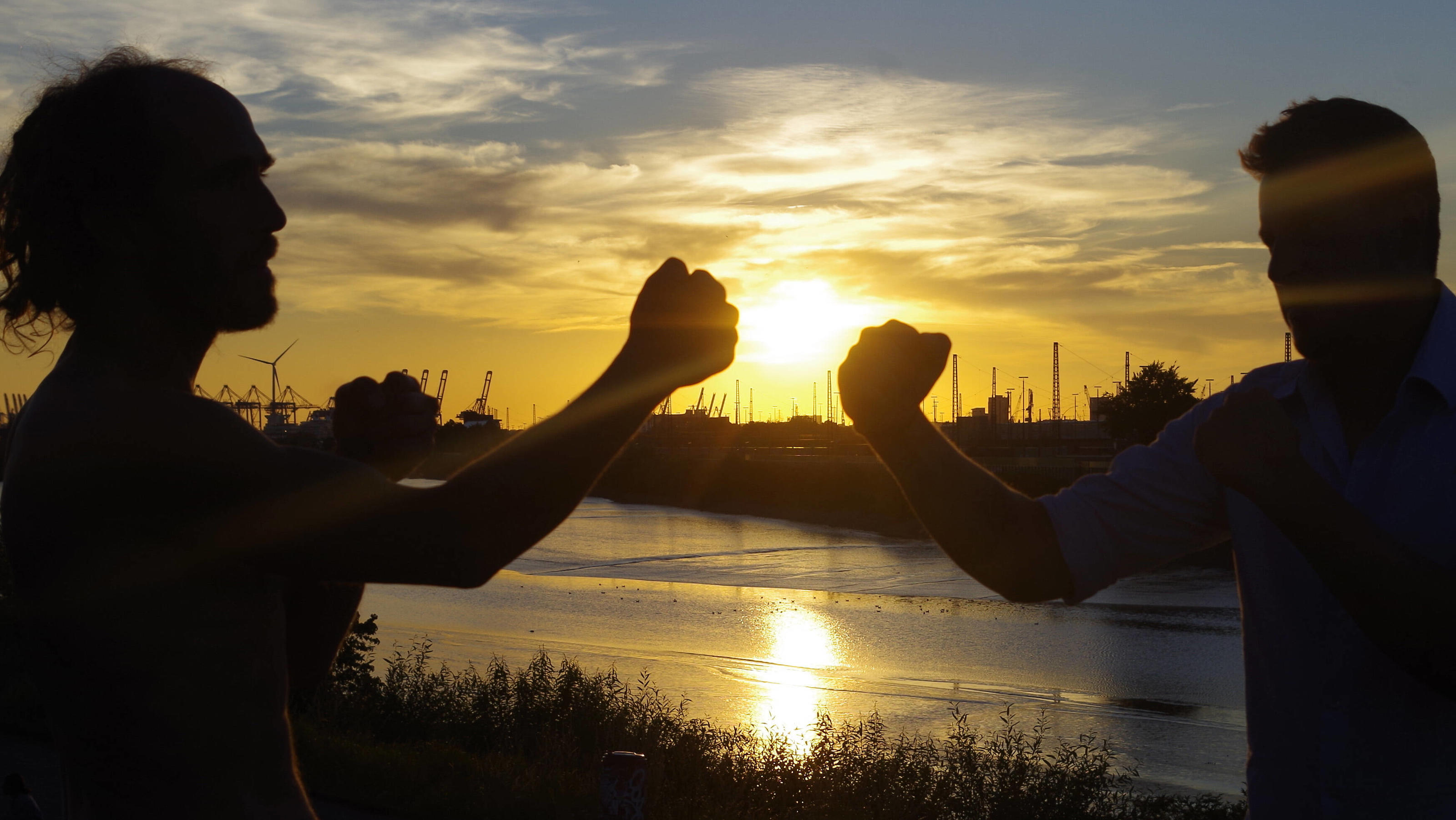 Wetterbericht für den 05.08.2020: Letzte Nacht zum Durchlüften, dann wird's heiß Wetter-Feature: Sonnenboxen auf einem Deich in Hamburg. Zwei junge Männer kämpfen aus Spaß miteinander und genießen den Abend eines traumhaften Sommertages. *** Weather Feature Sunboxing on a dike in Hamburg Two young men fight with each other for f