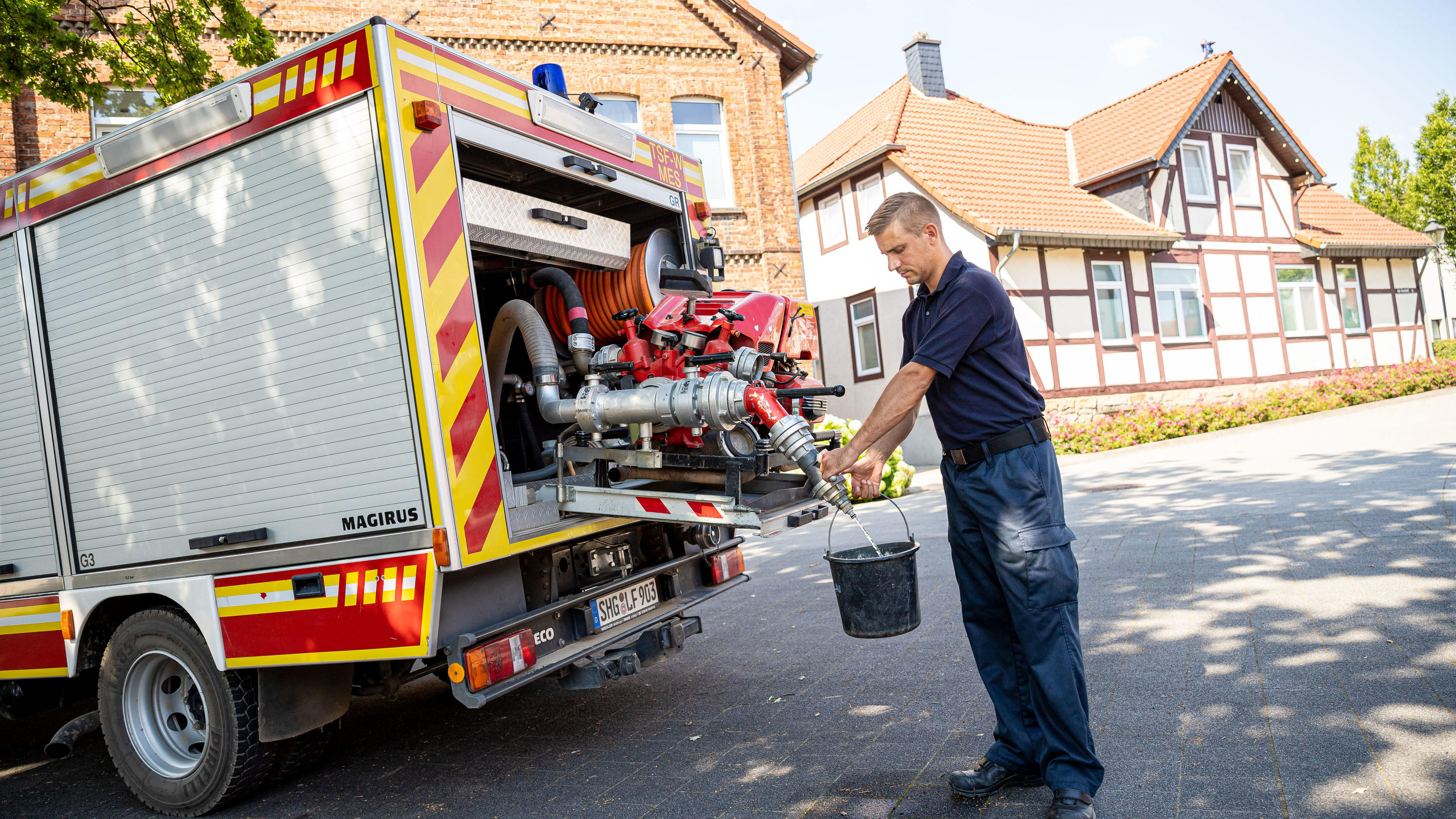 Lauenau (Kreis Schaumburg) geht das Leitungswasser aus: Hähne könnten trocken bleiben 08.08.2020, Niedersachsen, Lauenau: Einsatzkräfte der Freiwilligen Feuerwehr Lauenau zapfen Löschwasser aus dem Tank eines ihrer Einsatzfahrzeuge. In der Gemeinde im Landkreis Schaumburg ist die Wasserversorgung nach warmen Tagen und während der Coro