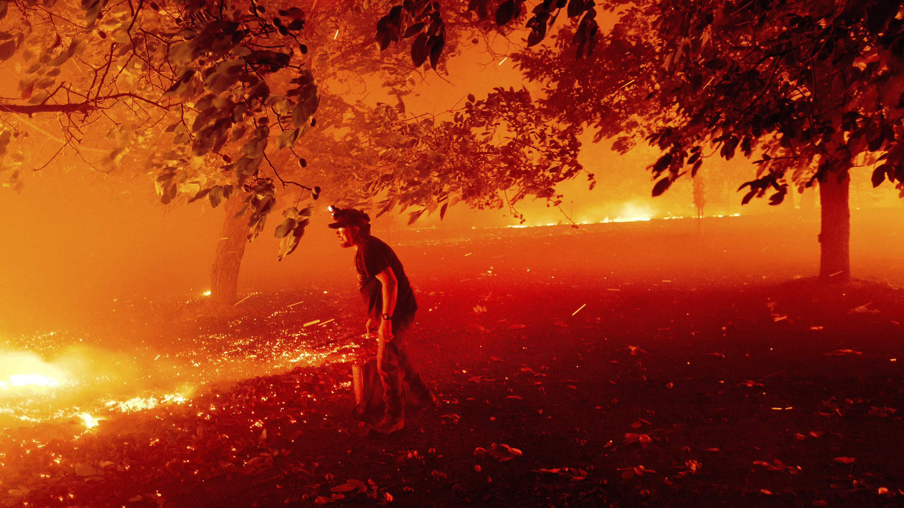 Rauchwolken der Kalifornien-Waldbrände ziehen bis Europa - Wie gefährlich ist der Rauch? 19.08.2020, USA, Vacaville: Matt Nichols versucht das Feuer an seinem Haus bei einem Waldbrand zu löschen. Mehr als zwei Dutzend Waldbrände lodern im US-Bundesstaat Kalifornien. Gouverneur Newsom rief wegen der Feuer und der anhaltenden Sommerhitze d