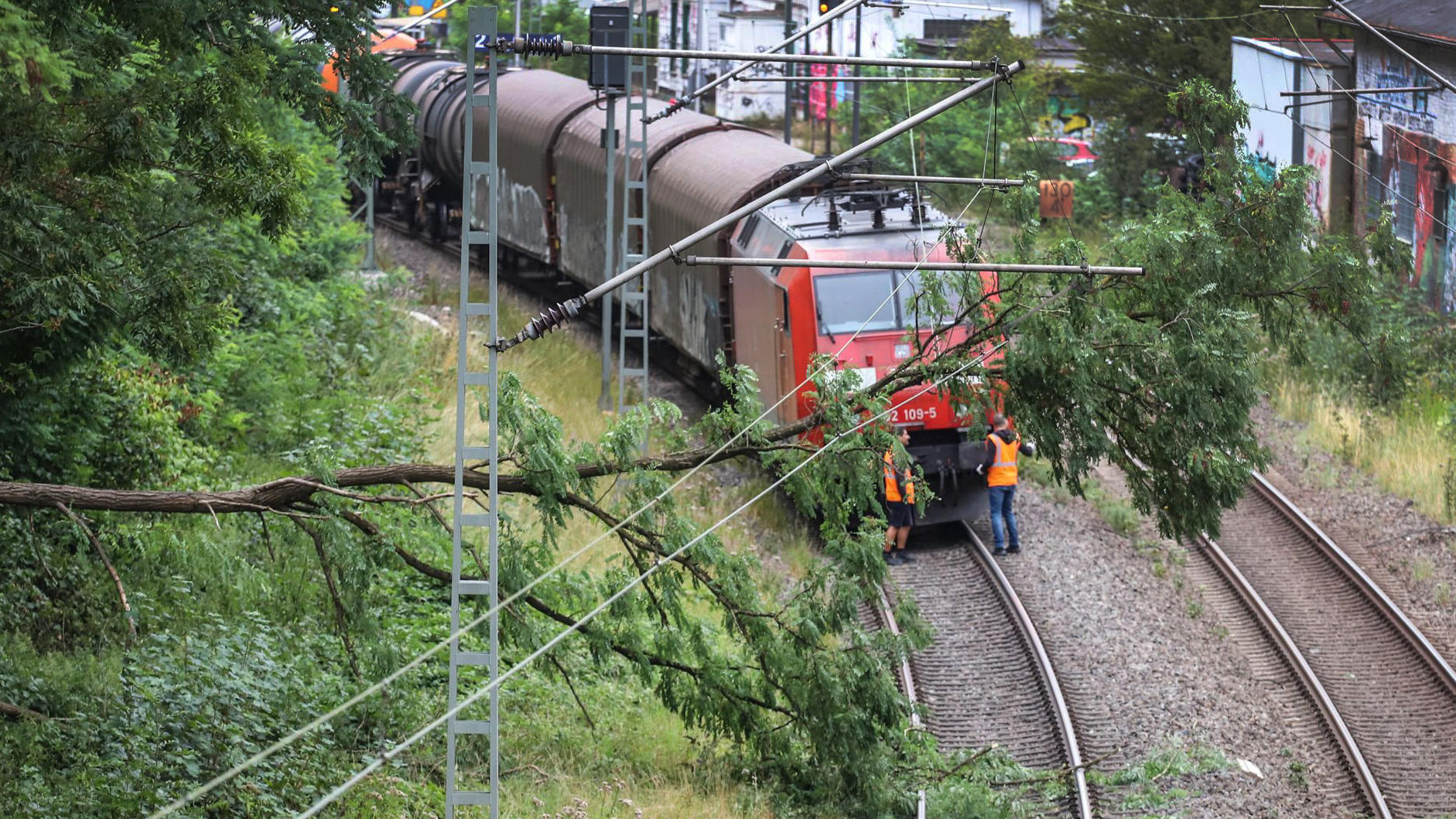 Sturm Kirsten: Das war der Live-Ticker 26.08.2020, Nordrhein-Westfalen, Ennepetal: Ein Baum liegt vor einem Güterzug auf den Oberleitungen. Sturmtief «Kirsten» hat am Mittwochmorgen in Nordrhein-Westfalen zahlreiche Schäden angerichtet. Im Bahnverkehr haben etwa umgestürzte Bäume für Stre